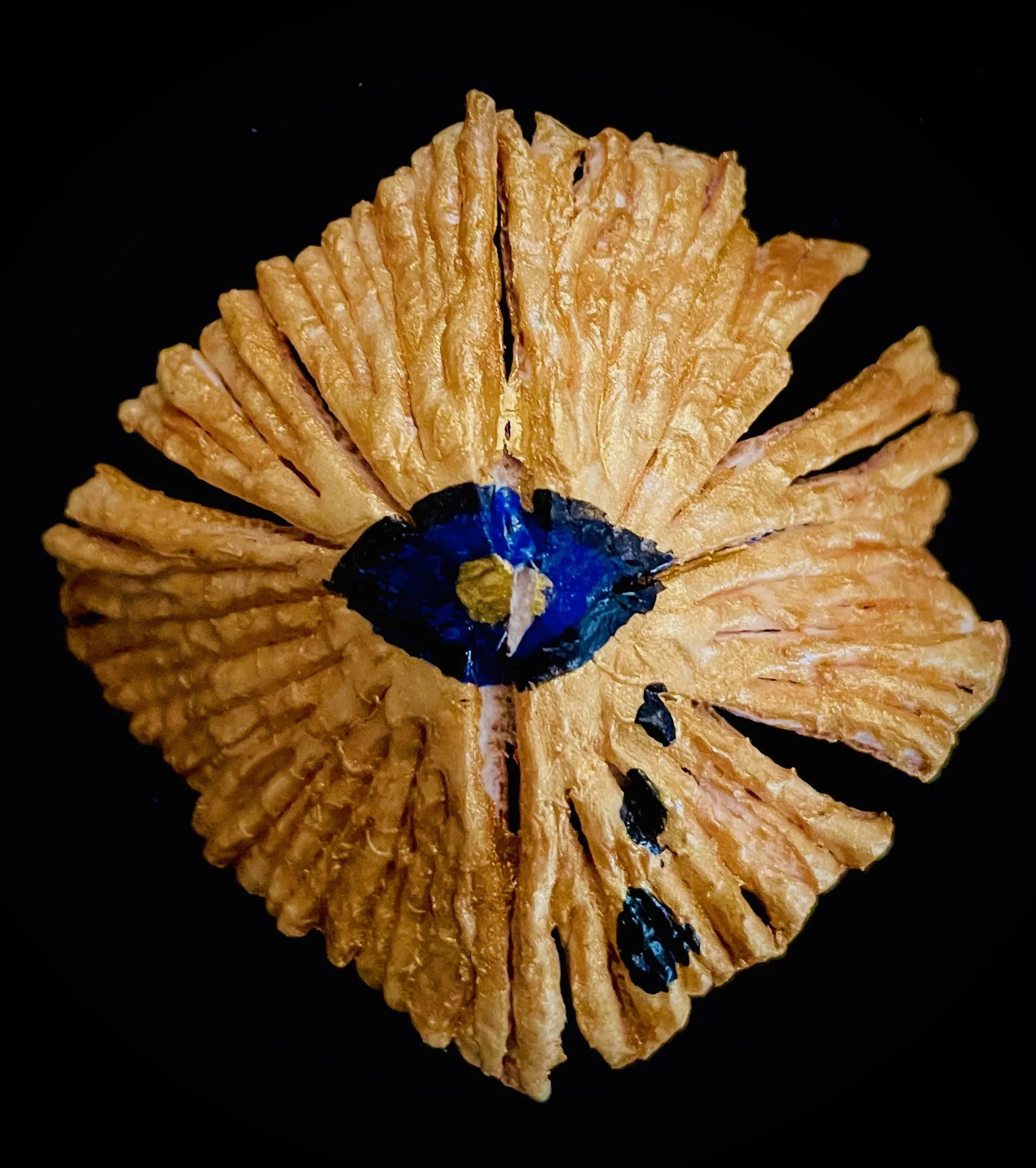 Close-up of a citrus rind with a small blue flower in the center on a black background.