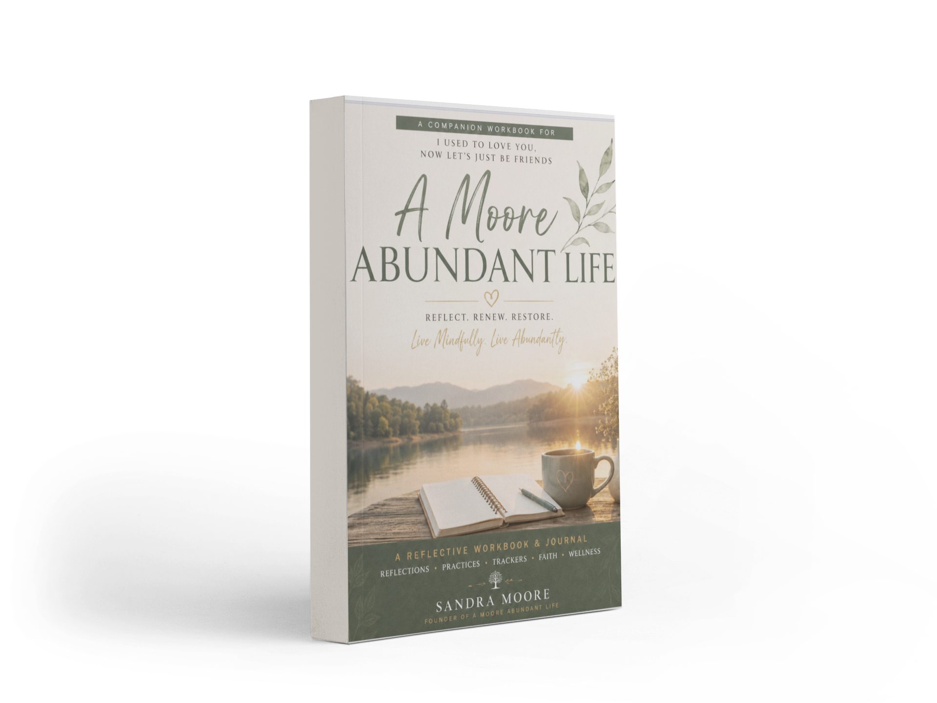 Book titled "A Moore Abundant Life" with a scenic lake view, a notebook, pen, and mug on a wooden surface at sunset.