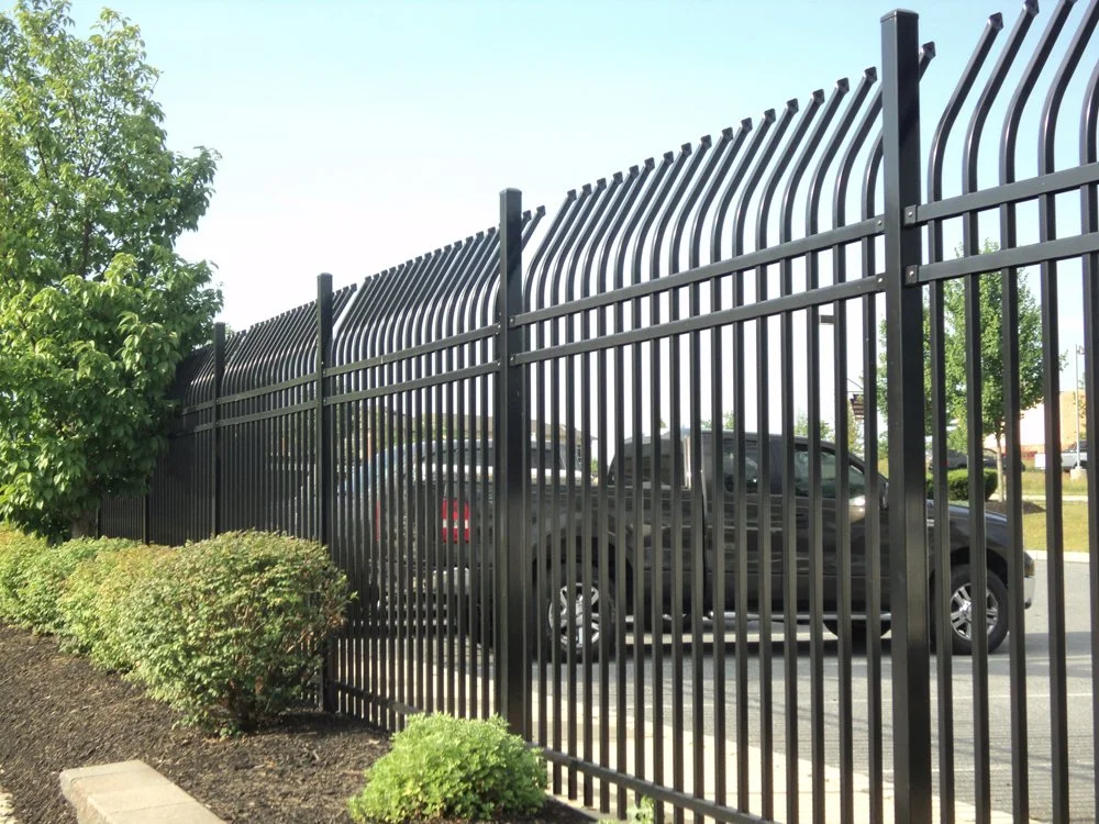 A tall black metal fence with pointed tips, ornamental black metal fence, steel fence, wrought iron, outdoor