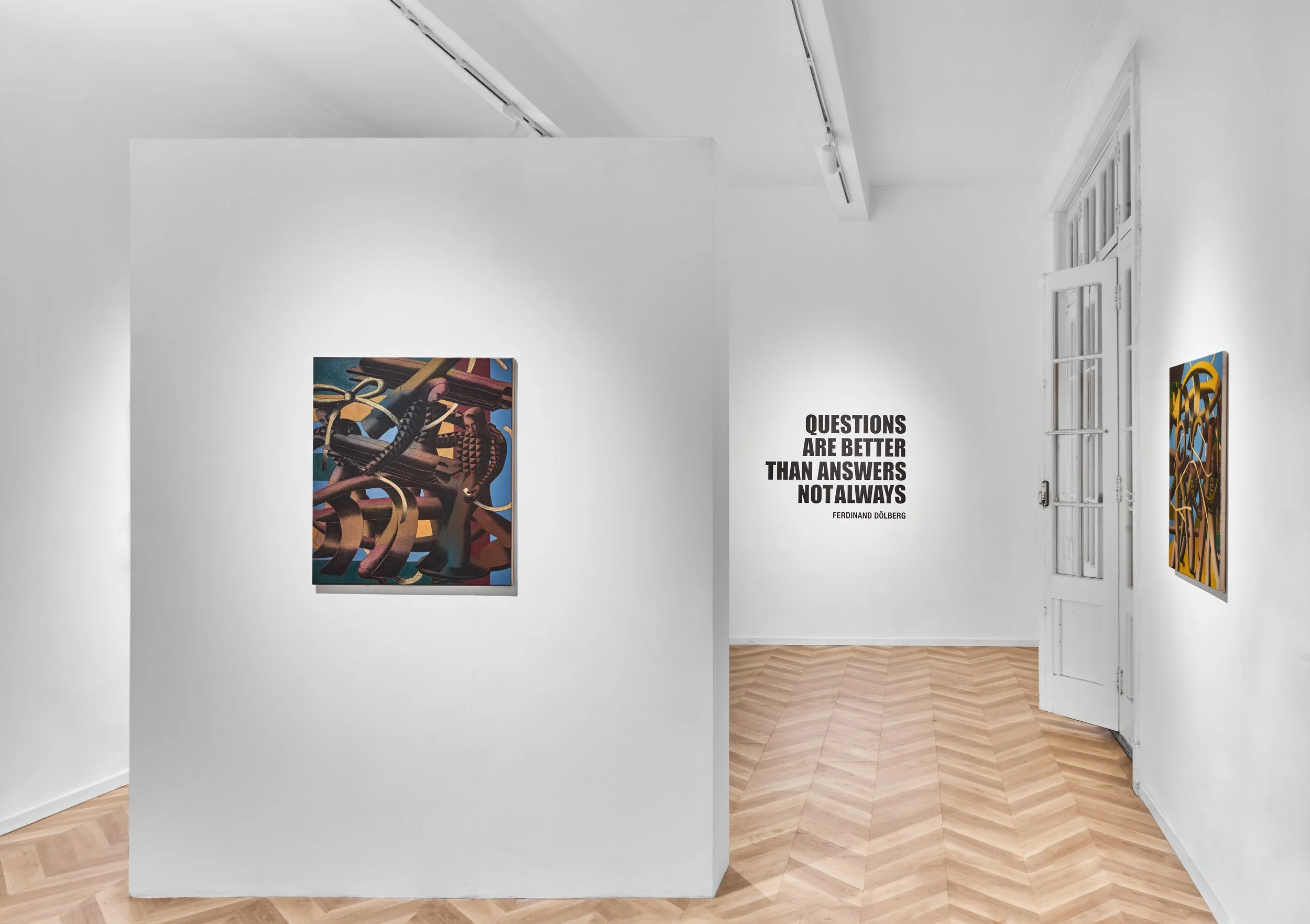 An art gallery with white walls and wooden floors displaying abstract paintings. Visible text on the wall reads, "Questions are better than answers, not always" by Ferdinand Dölberg. There is a tall window on the right side.