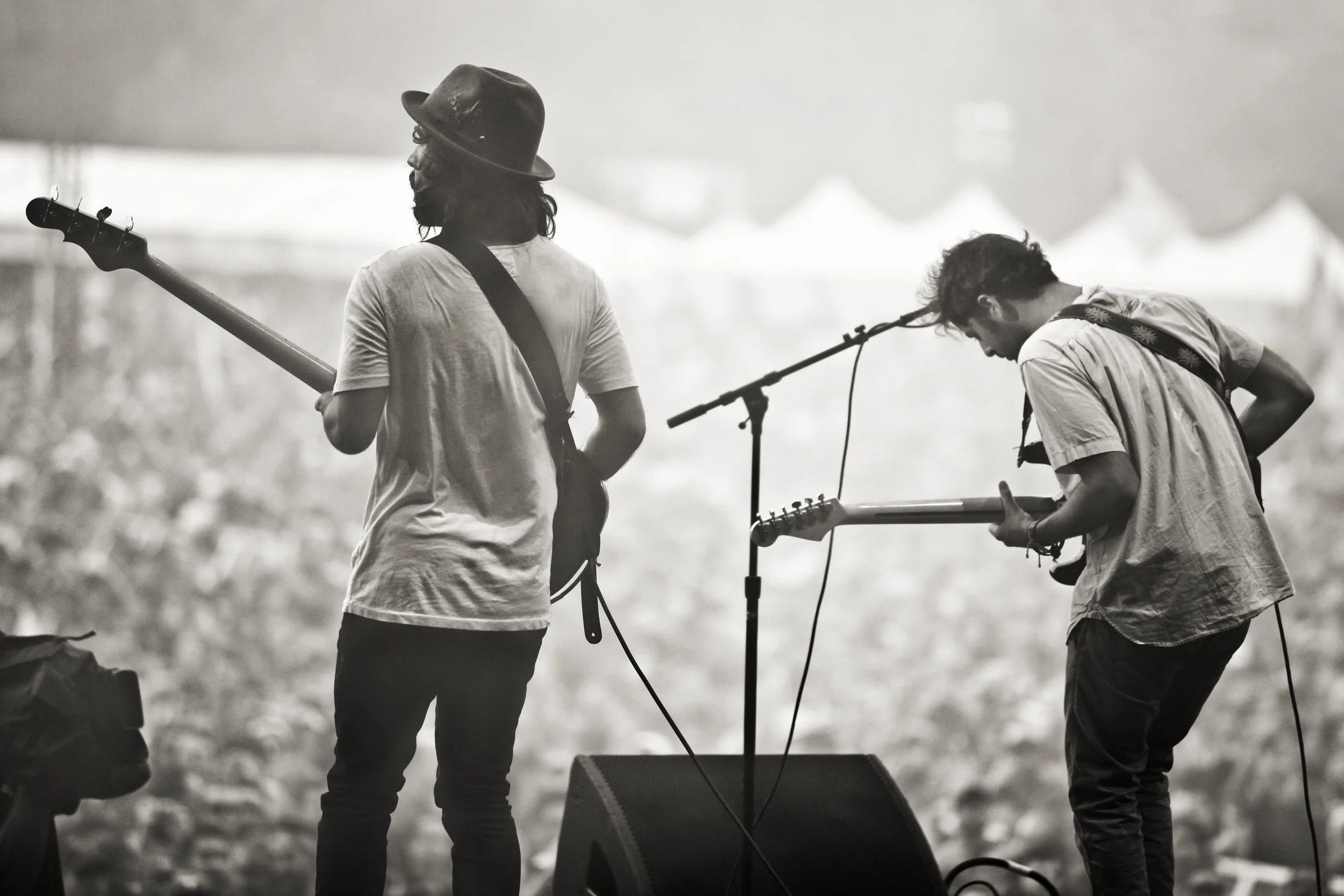 Young the Giant performing live at a music festival, photographed from the stage in black and white. Documentary music photography capturing the energy between performers and audience during a live concert.