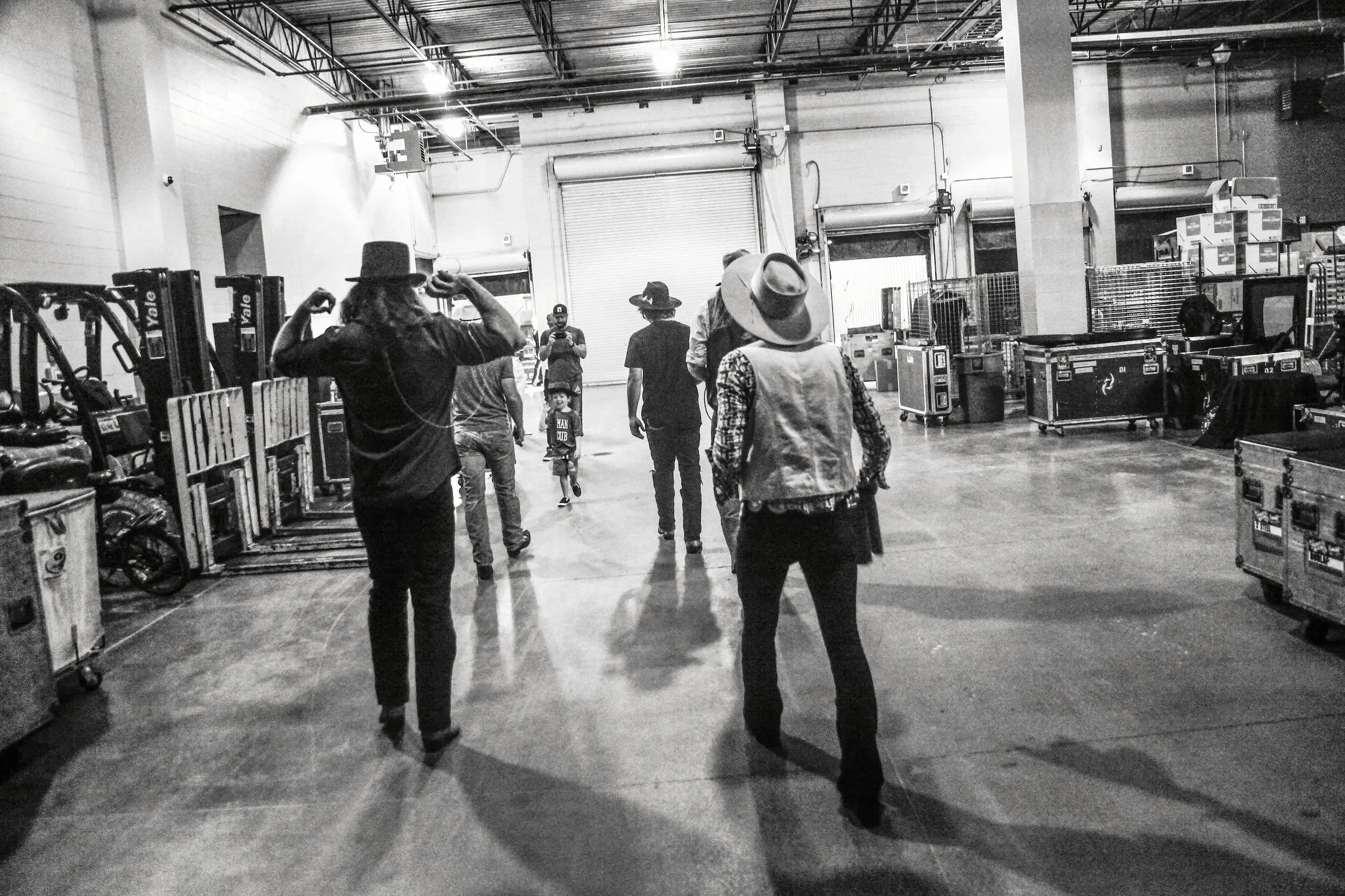 Whiskey Myers walking to their dressing rooms through a backstage corridor after performing a concert at the HEB Center in Cedar Park, Texas.