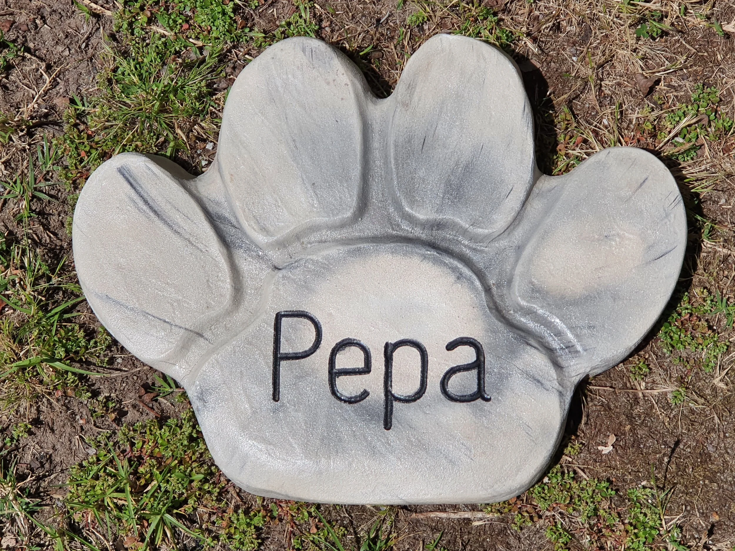 Concrete paw print garden ornament with engraving.