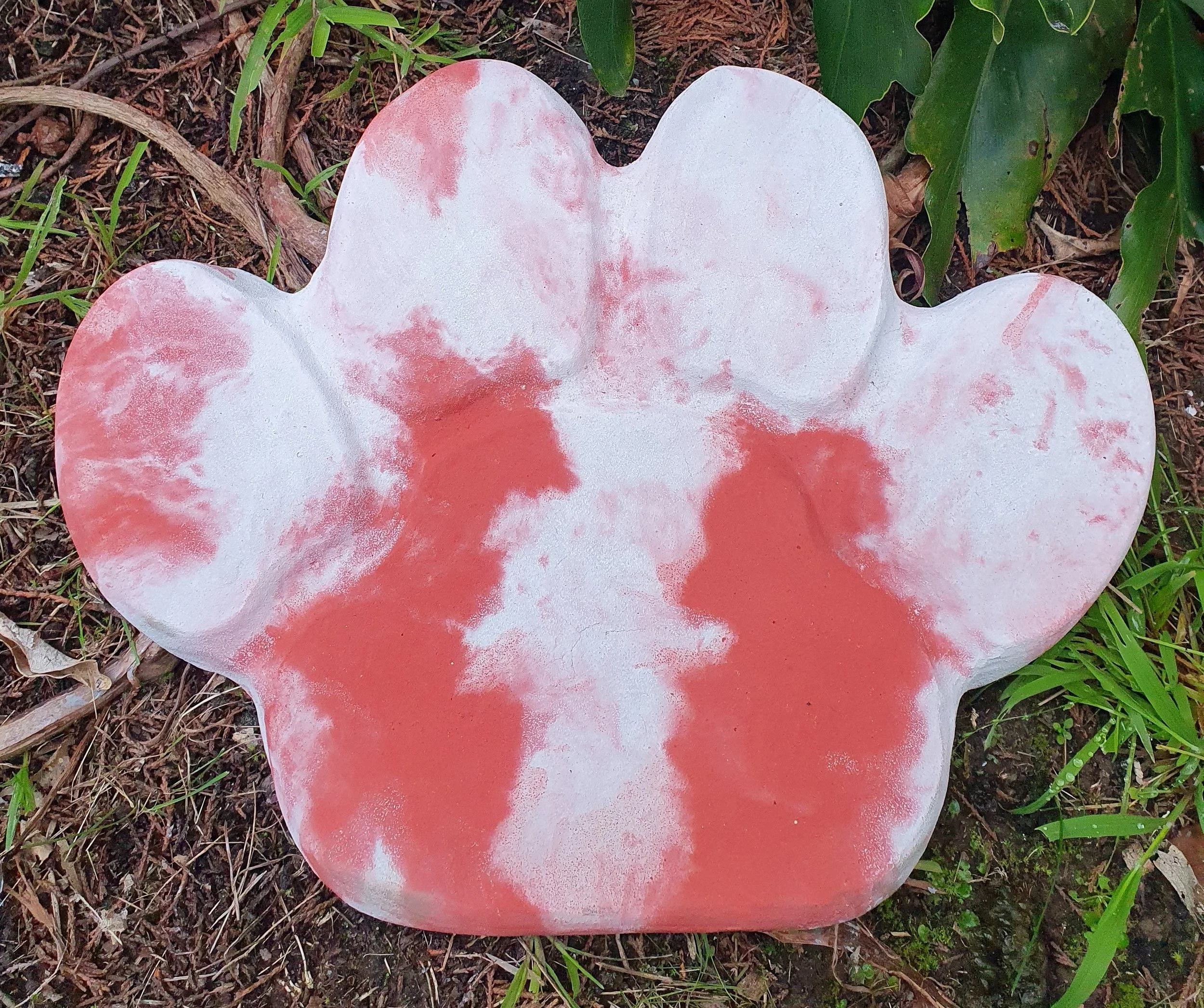 Paw print garden ornament in red and white colour, ready to be engraved.