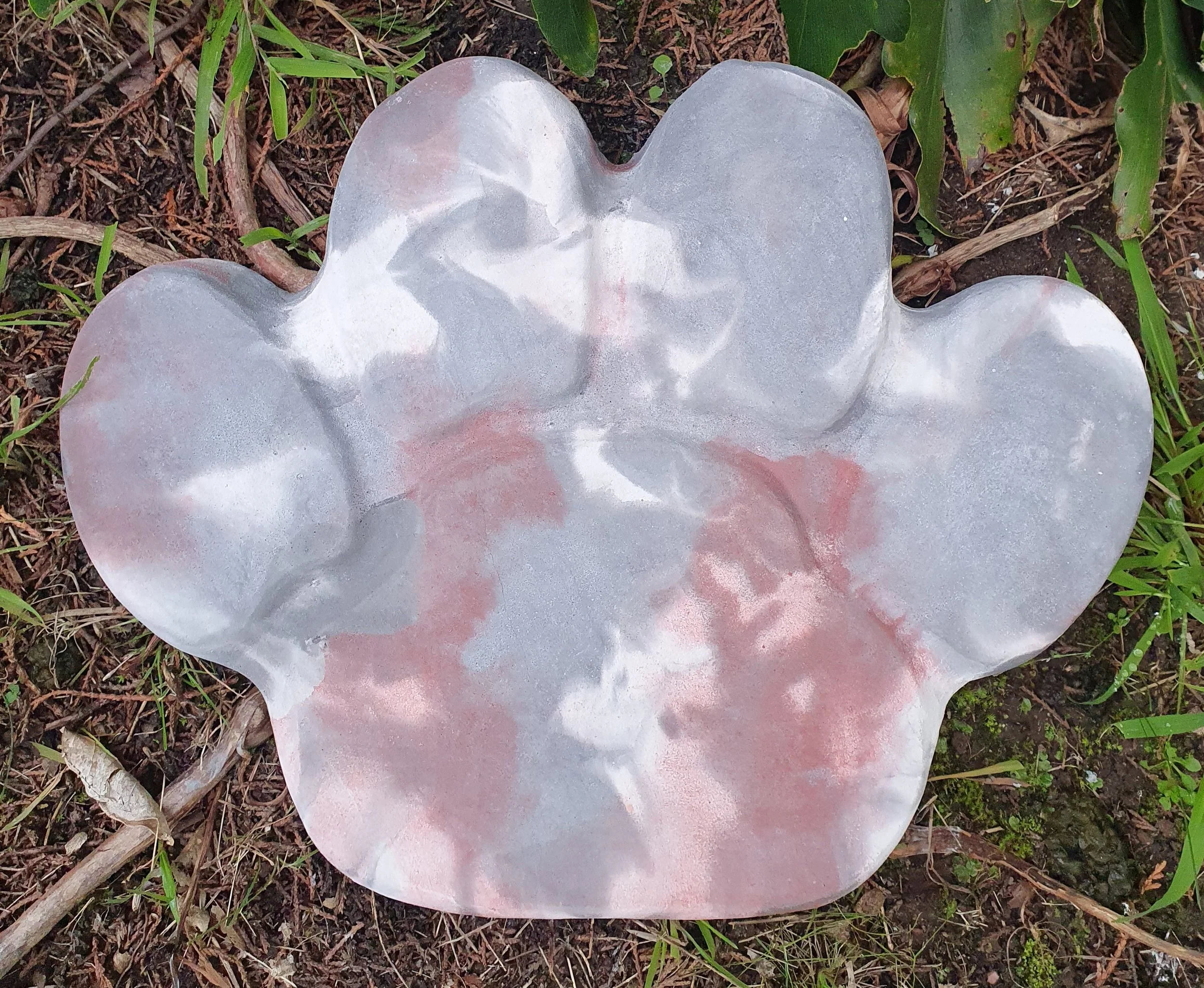 Paw print concrete garden ornament in marbled gray colour, ready to be engraved.