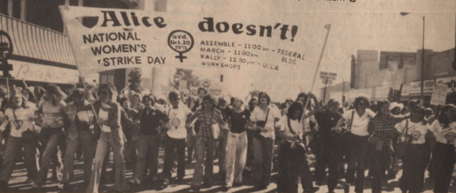 A vintage black and white photograph of a large group of women protesting in the street, holding signs and banners, with one prominent banner reading 'Alice doesn't!' and references to Women's Strike Day, with scheduled events such as assembly, rally
