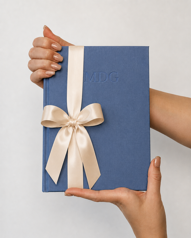 Story linen covered book with cream ribbon being held