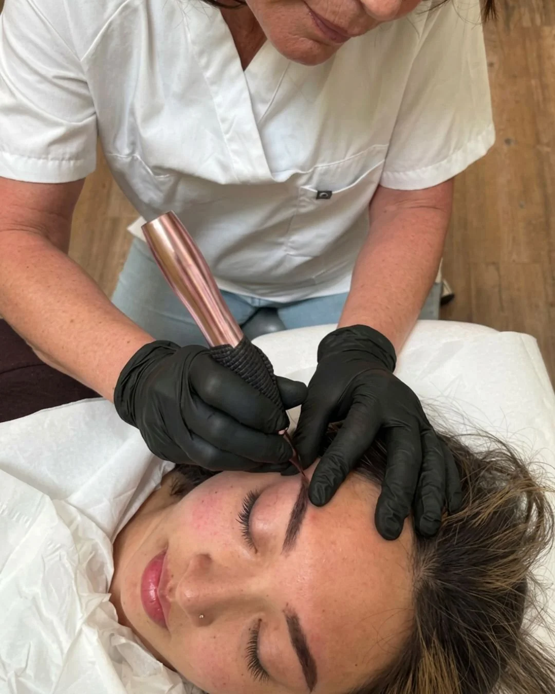 A woman with getting her eyebrows treated as part of the permanent makeip hair strokes procedure.