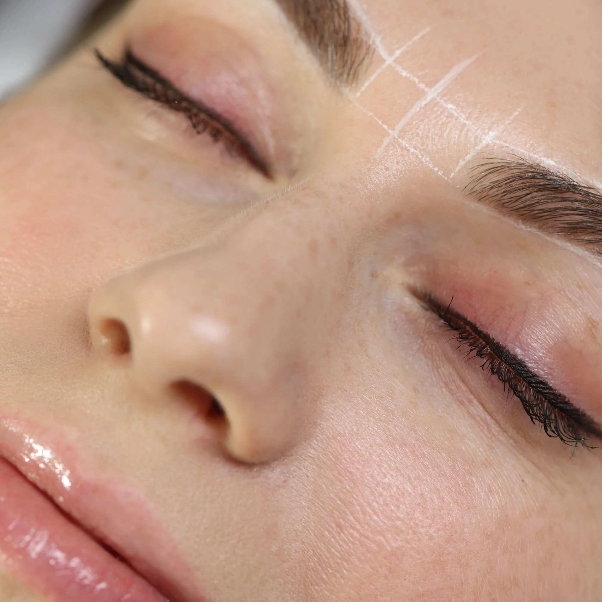Close-up of a person's face showing closed eyes and eyebrows, with visible skin texture and eyelash detail.