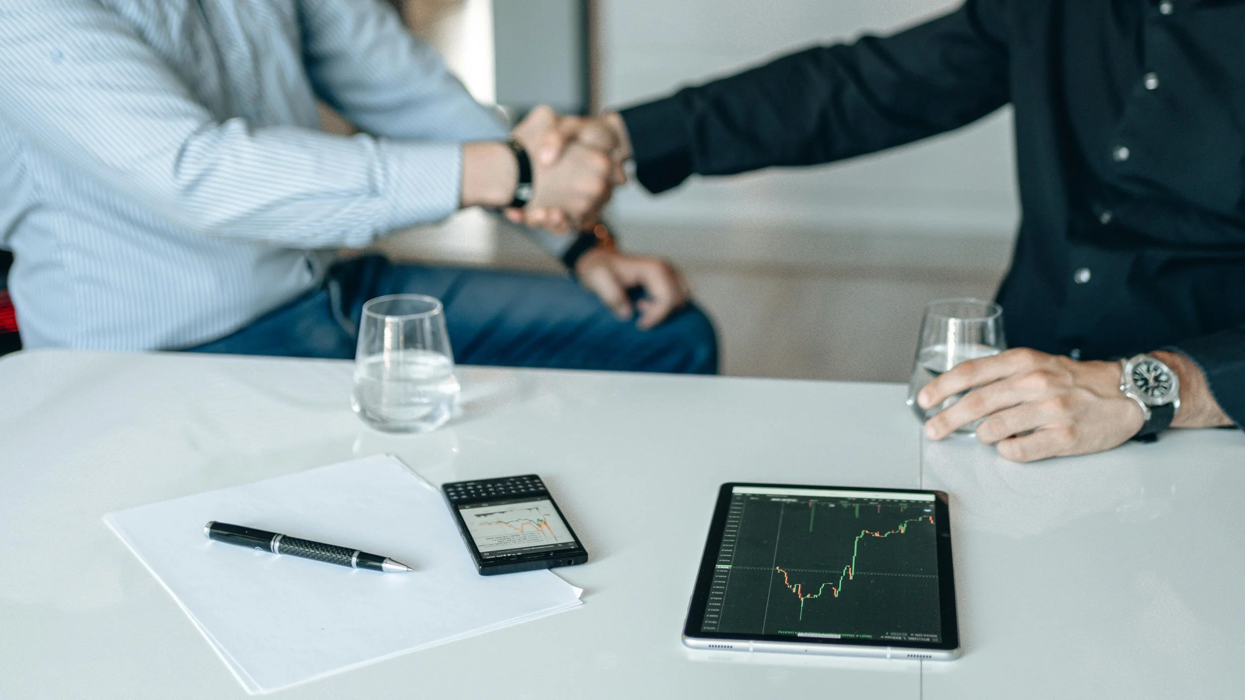 Business professionals shaking hands after discussing coverage options with a trucking insurance broker.