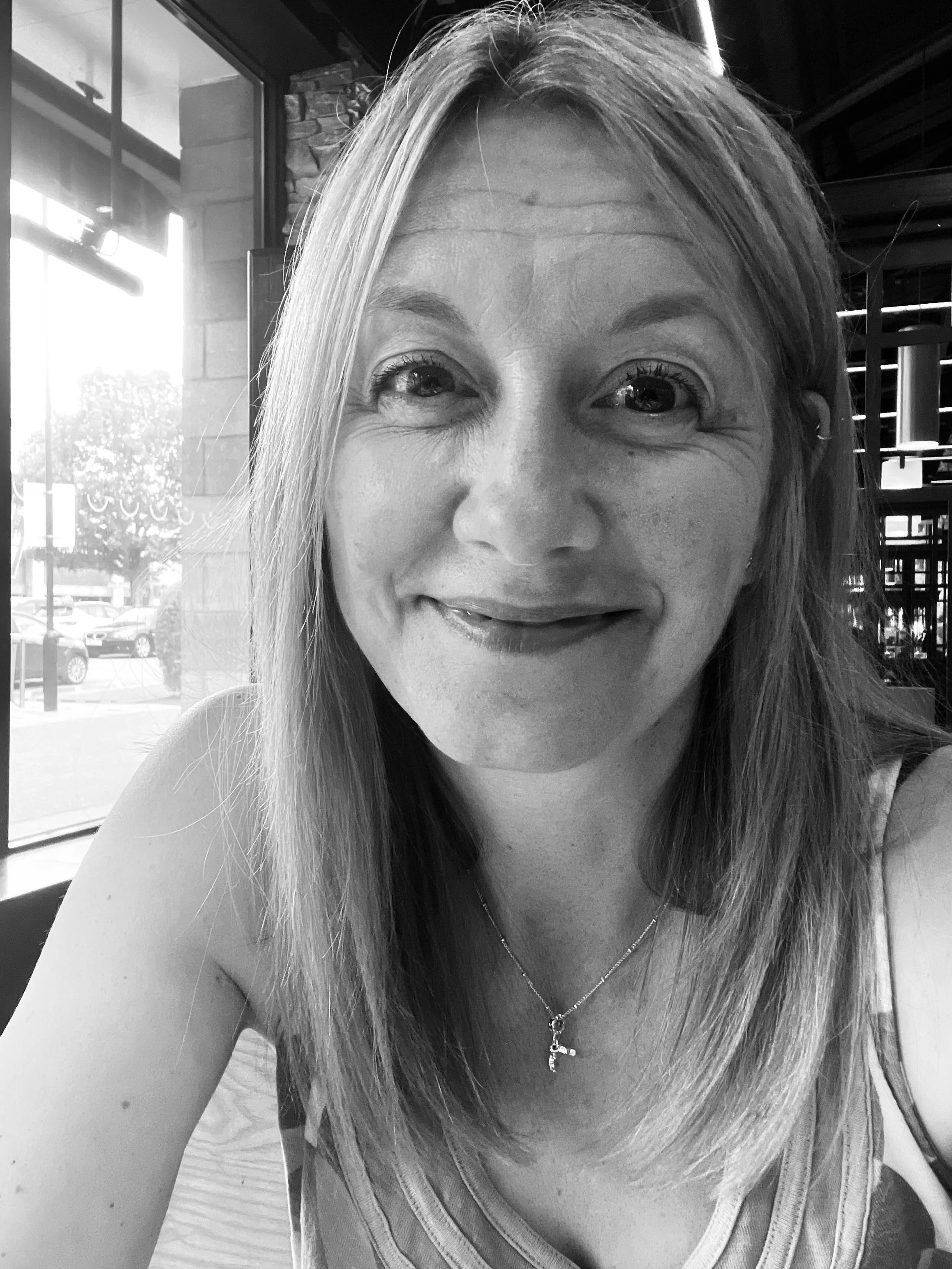 Woman therapist sitting inside, smiling,  looking relaxed and friendly.