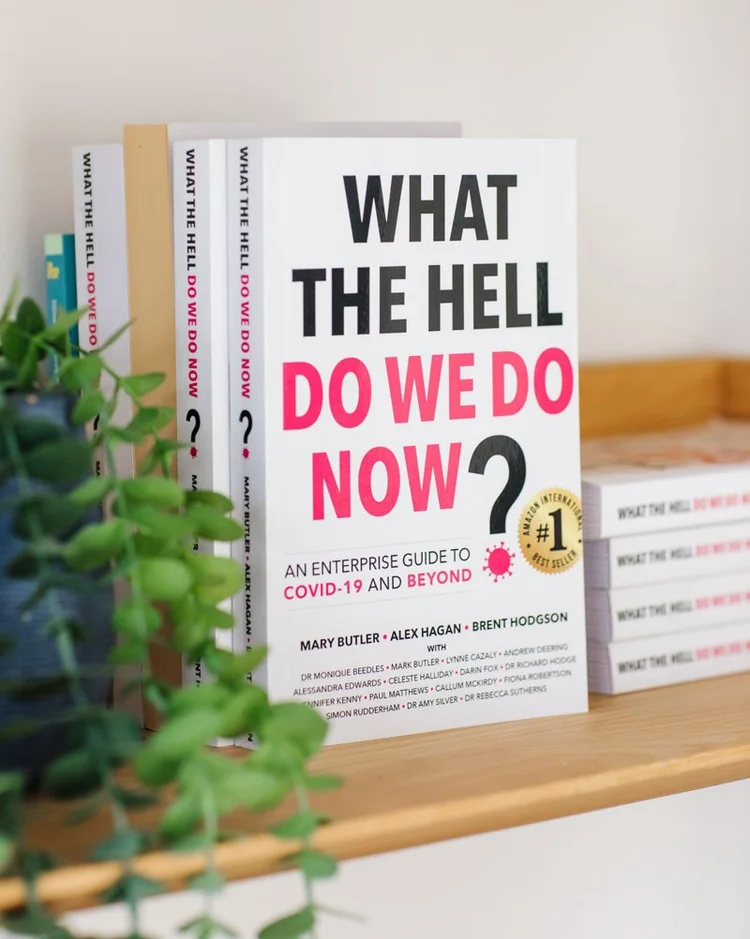 Multiple copies of What The Hell Do We Do Now? displayed on a shelf