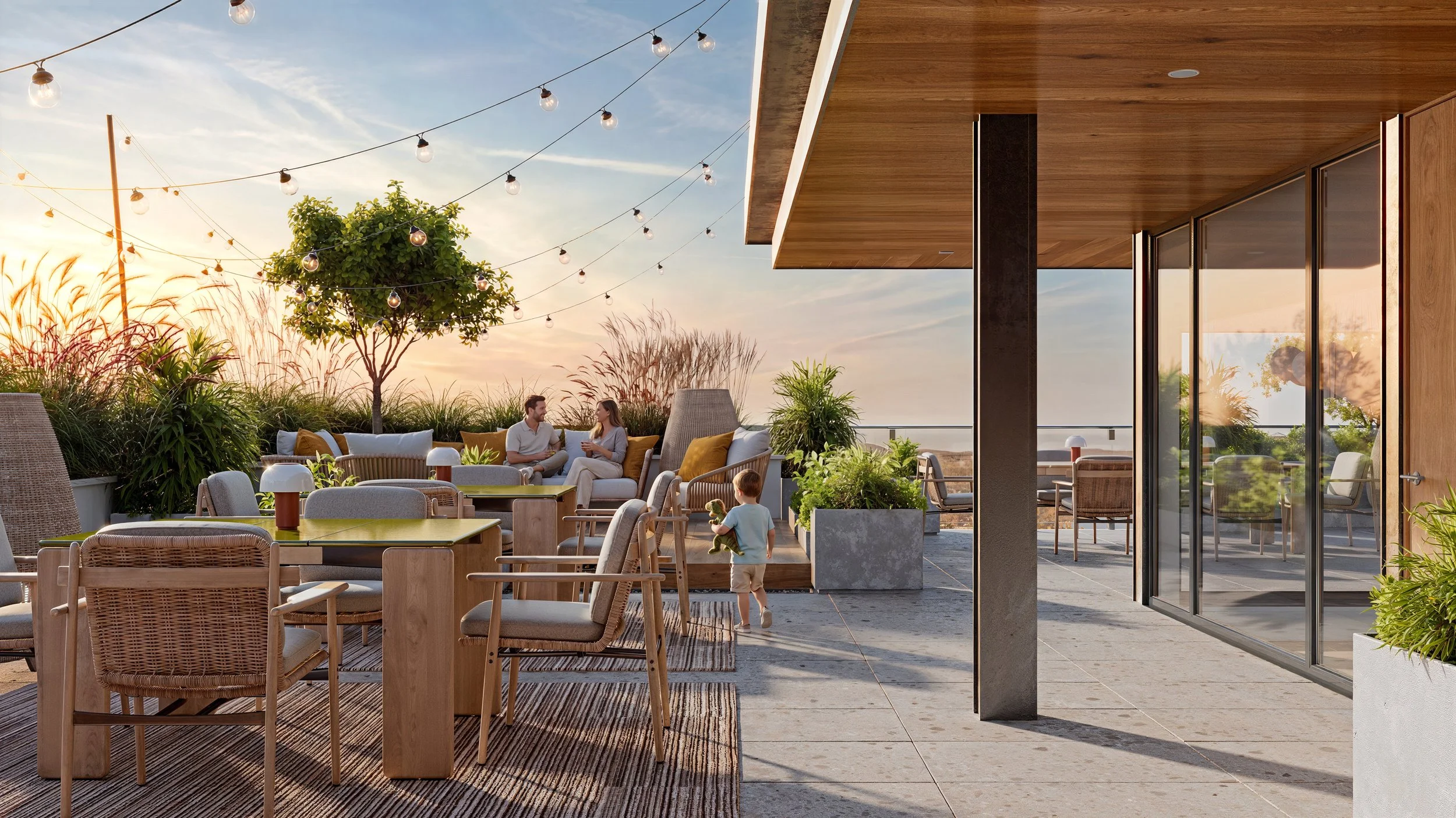 A rooftop patio with string lights, a tree, and outdoor furniture where a man and woman are sitting and talking, a young boy is playing with a stuffed animal, and the setting sun illuminates the scene.