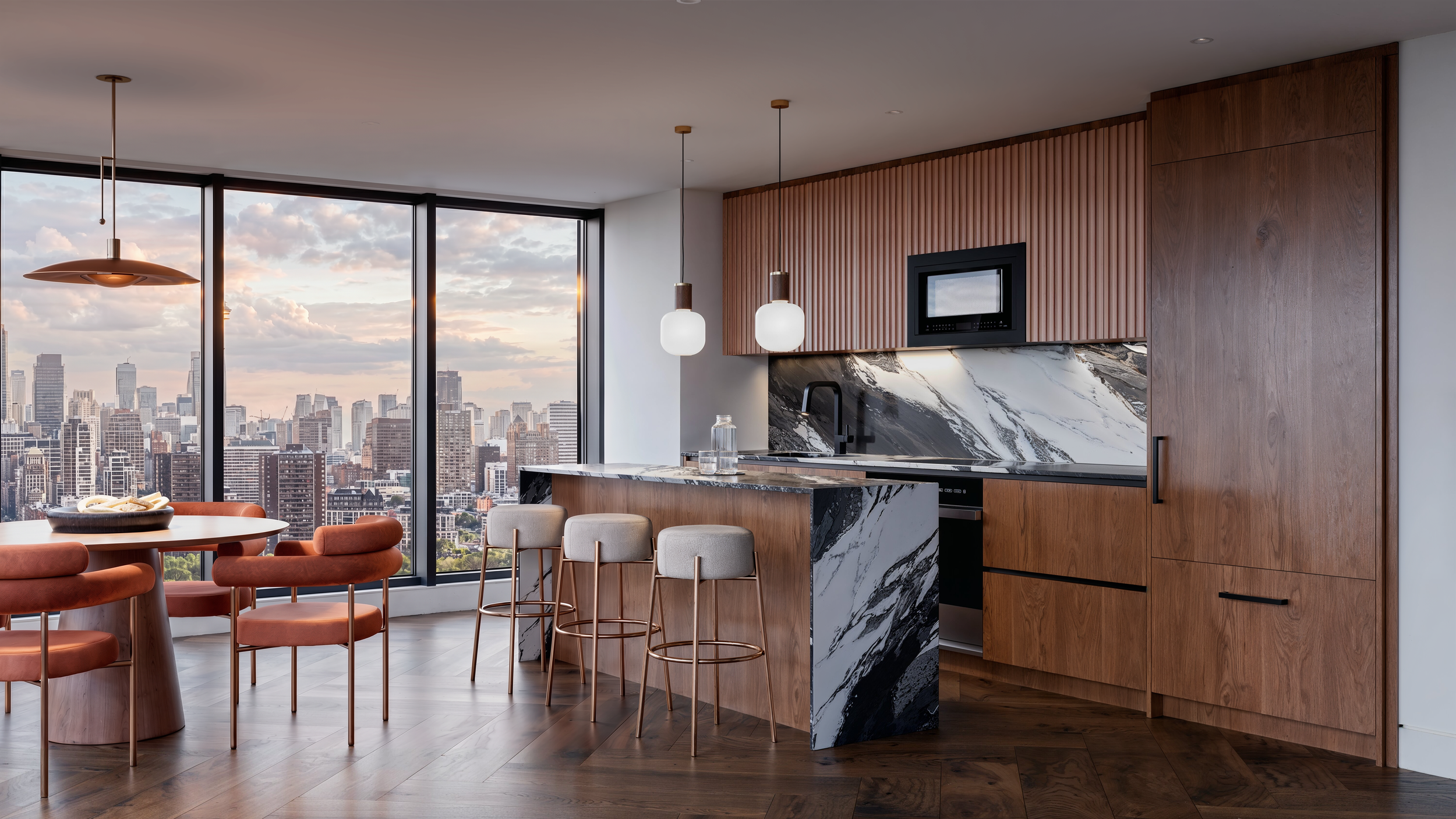 Modern apartment kitchen and dining area with large windows overlooking a city skyline, featuring wooden cabinets, marble countertops, a dining table with orange chairs, and hanging pendant lights.