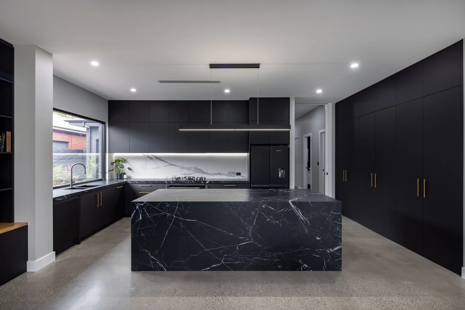 Vasari porcelain bookmatched island clad with 12mm stone. Black and white Vasari porcelain features on bench, island and splashback