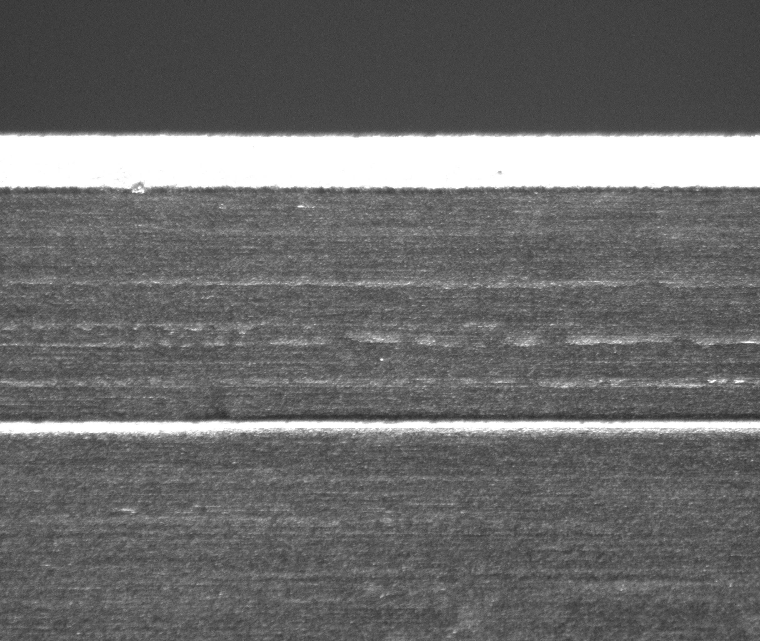 Close-up of a metallic object with a textured surface, showing a horizontal seam or joint.