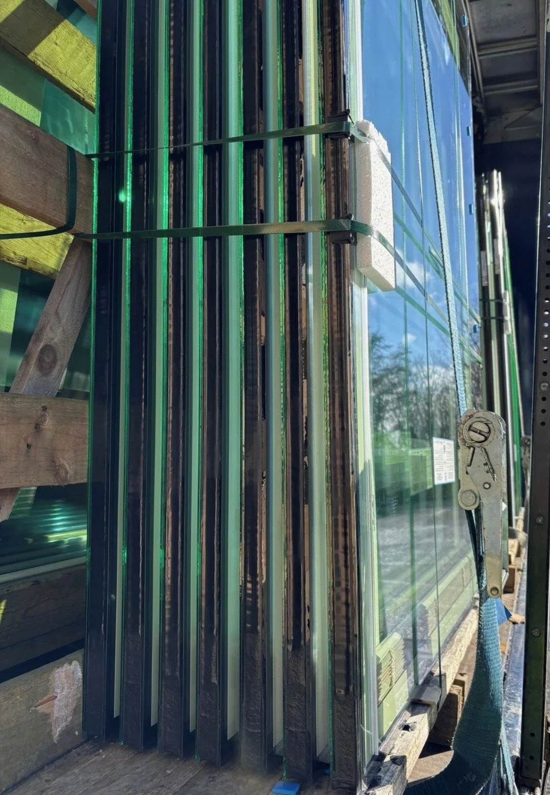 Piles de vitrages isolants avec stores vénitiens intégrés, conditionné sur un chevalet en bois de chez Lépée vitrage