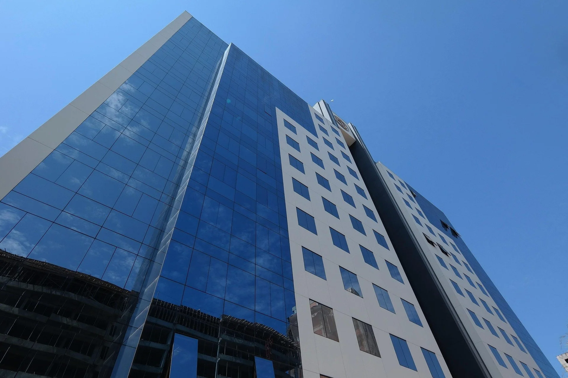 Gratte-ciel moderne avec façade en verre reflétant le ciel bleu