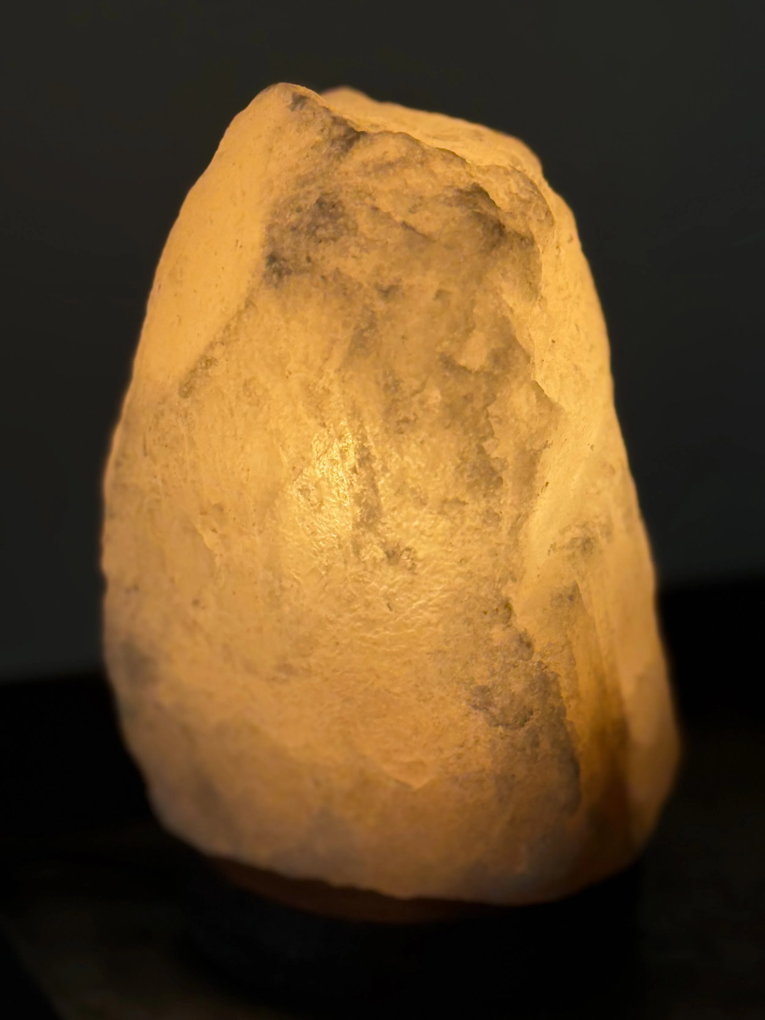 Close-up of a salt crystal lamp against a dark background.