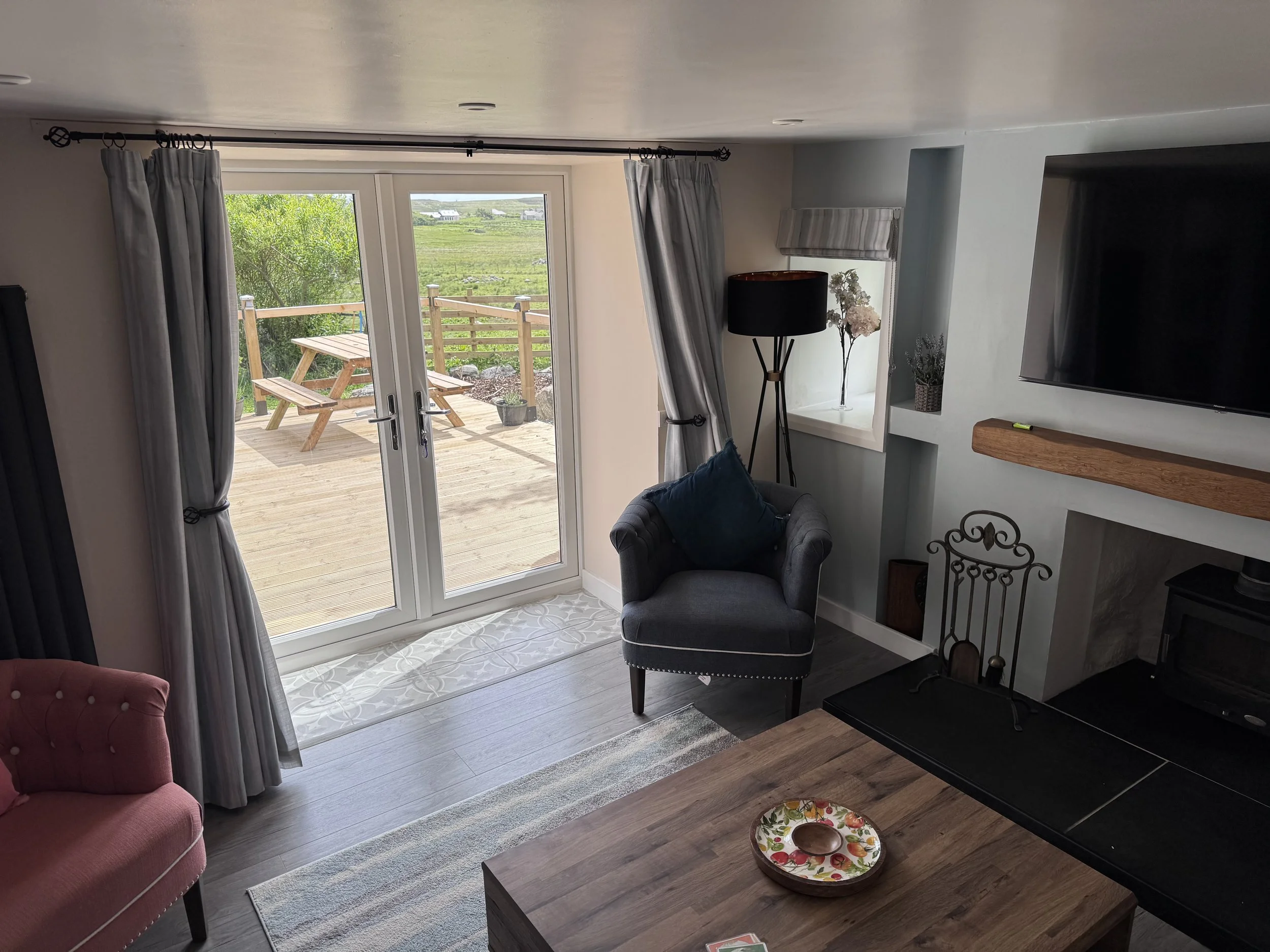 Living area at Stone’s Throw Cottage with patio doors opening onto the garden.