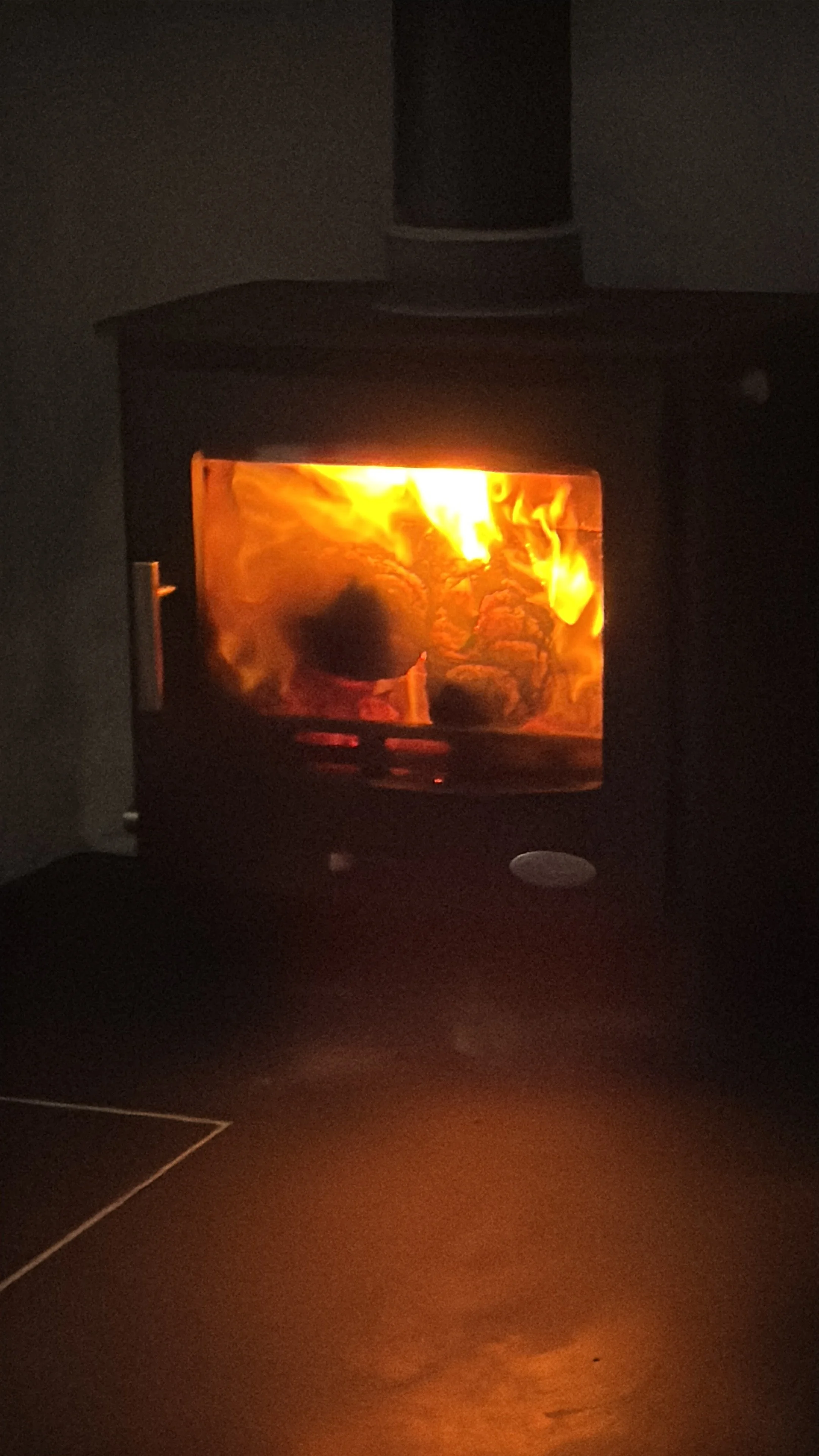 Wood-burning stove glowing inside Stone’s Throw Cottage, Calanais.