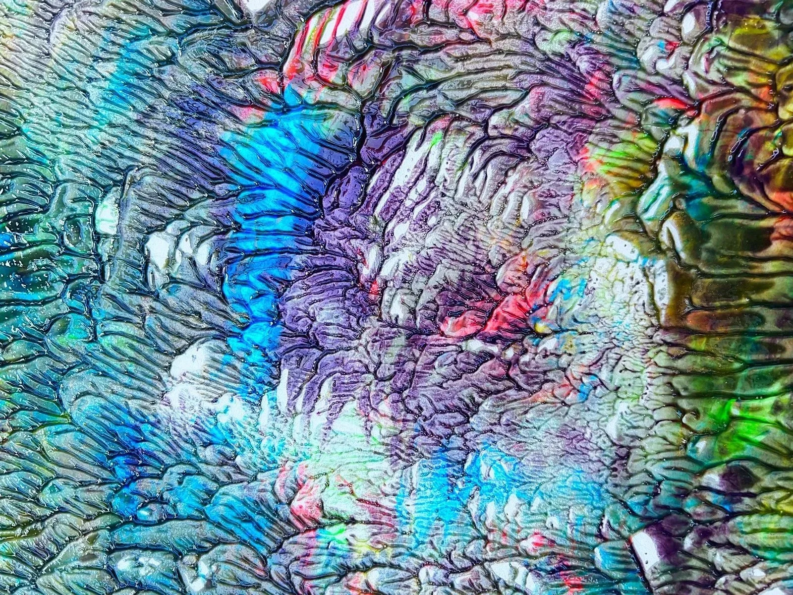 Close-up abstract image with vibrant, iridescent colors and textured, crackled patterns.