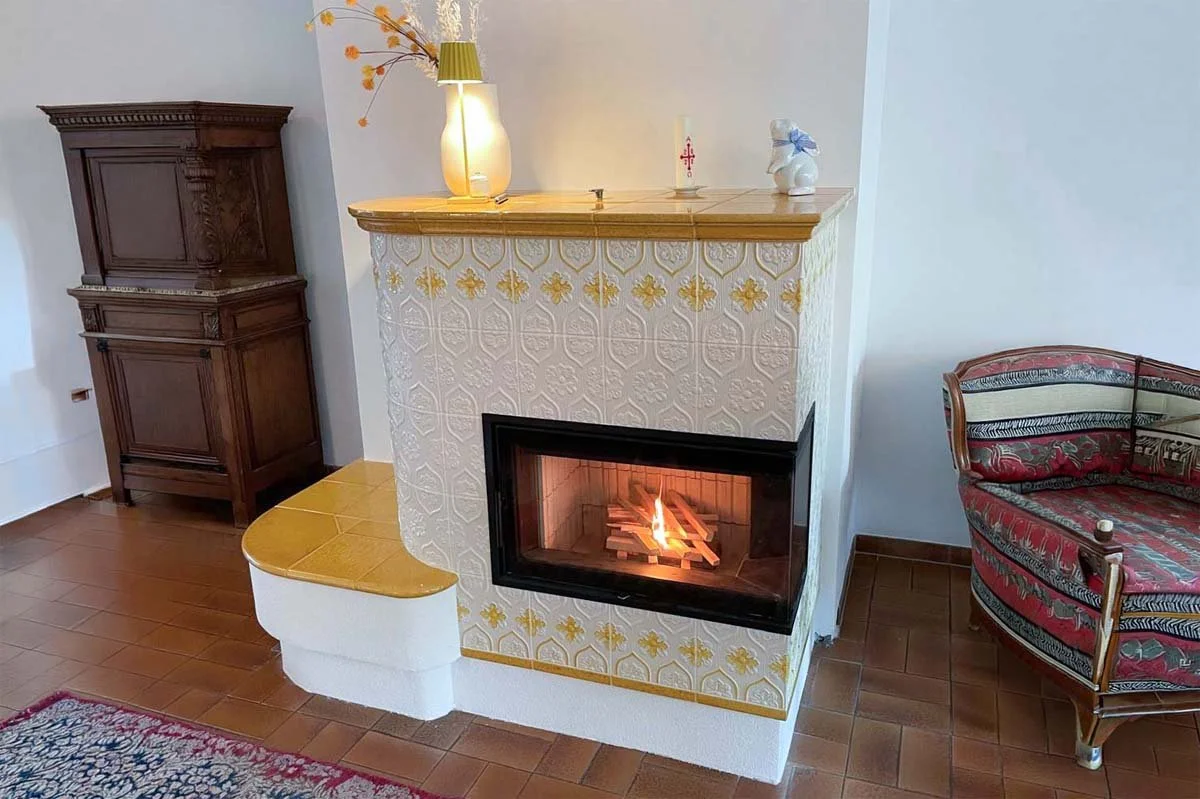 weiss-gelber kachelofen mit feuer drin