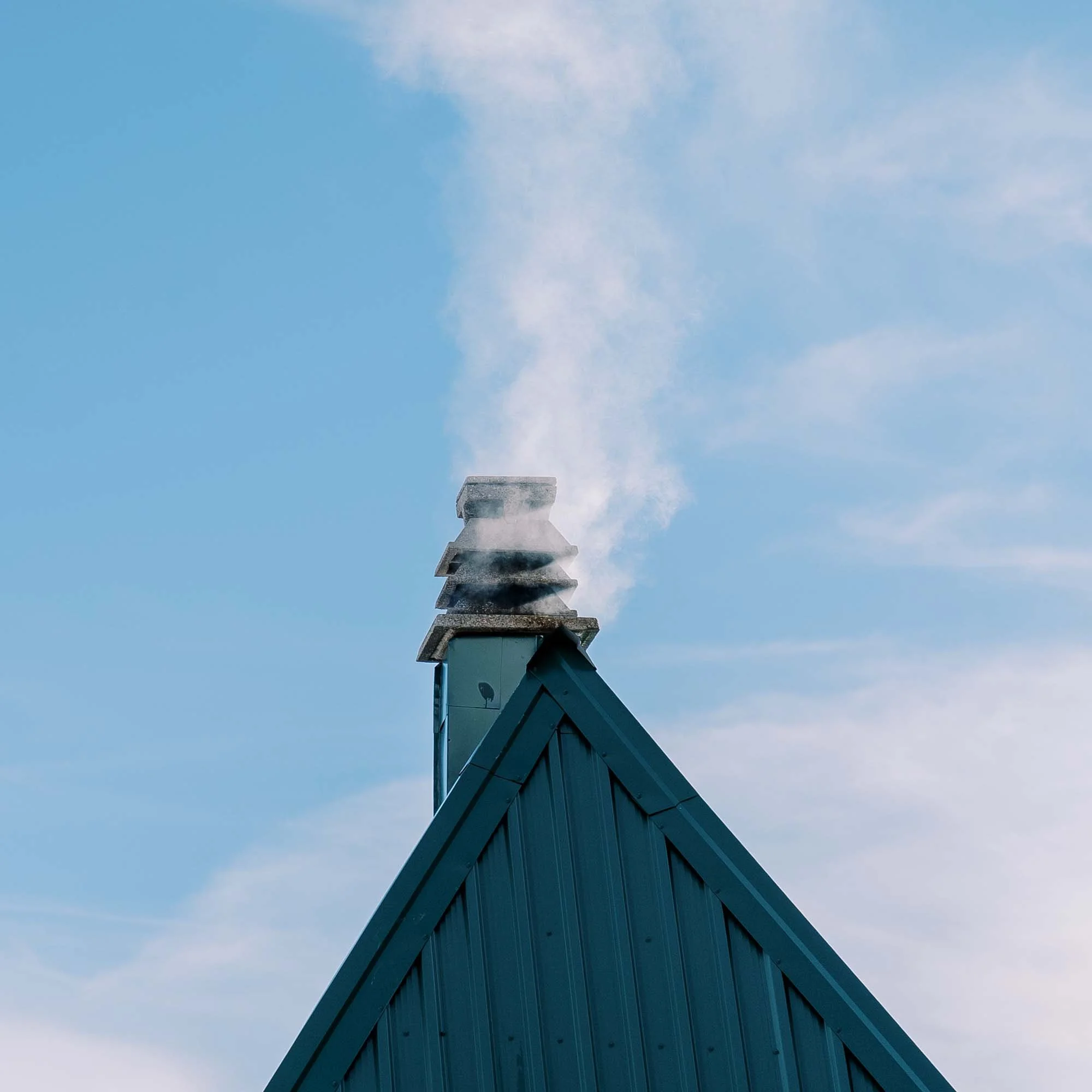 spitzdach mit einem kleinen schornstein oben drauf, qualmend