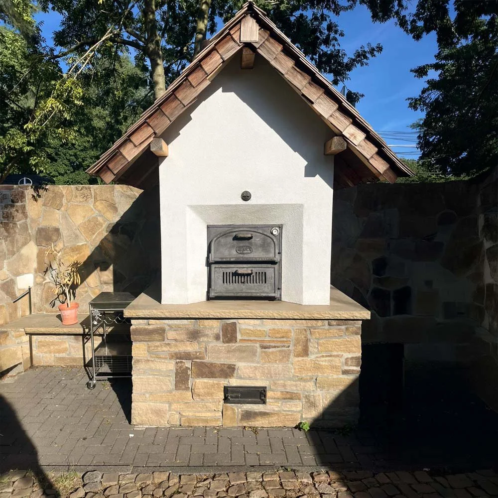 ein gemauerter im garten stehender pizzaofen