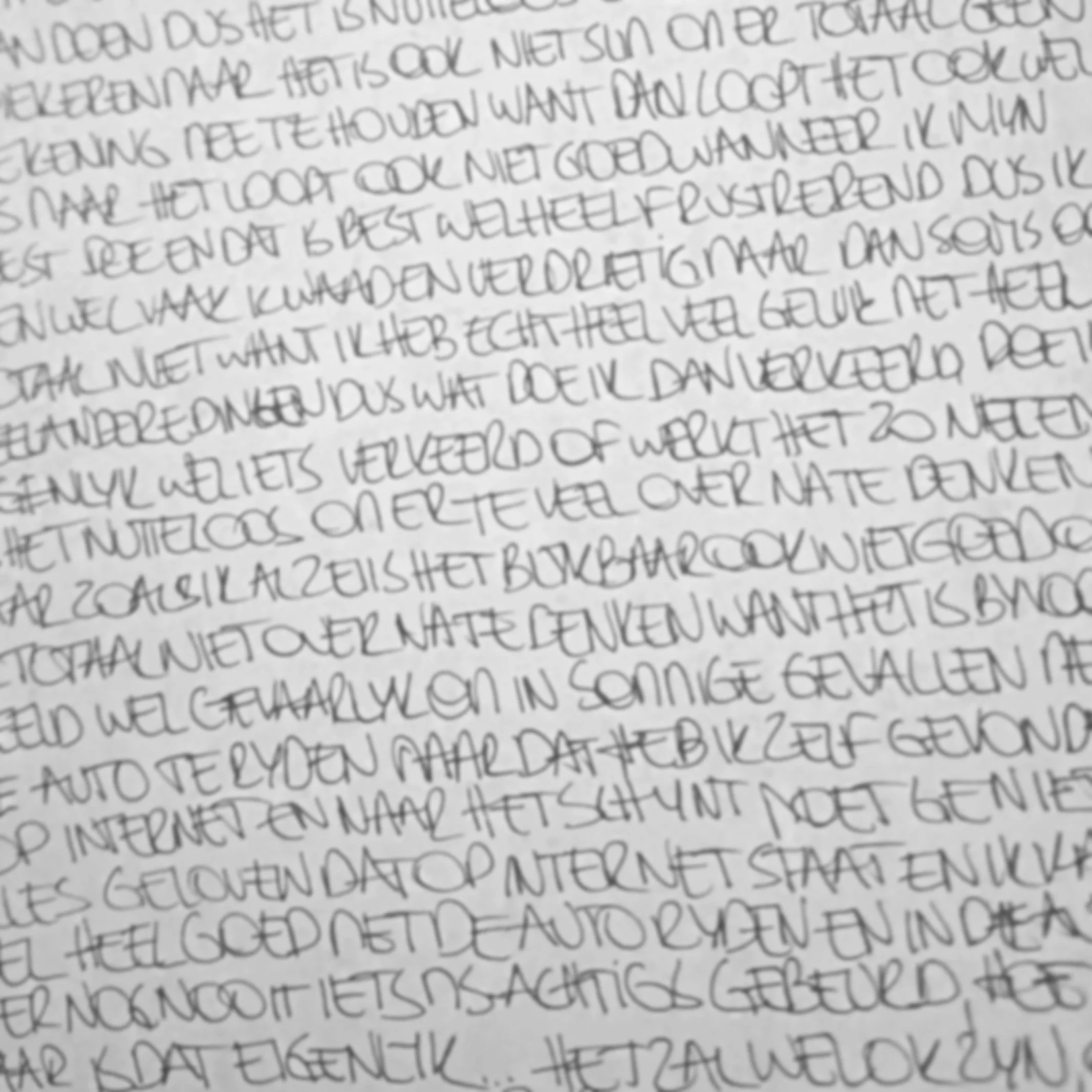A close-up view of handwritten text written in pencil on paper, with cursive and print lettering that is slightly out of focus.