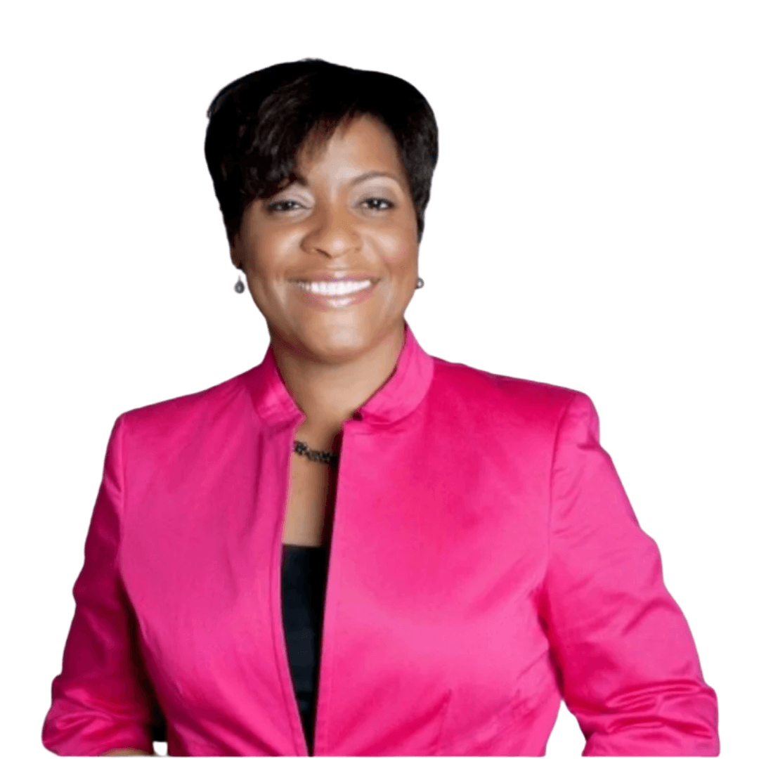 A woman with short dark hair is smiling and wearing a bright pink blazer over a black top, standing against a plain white background.