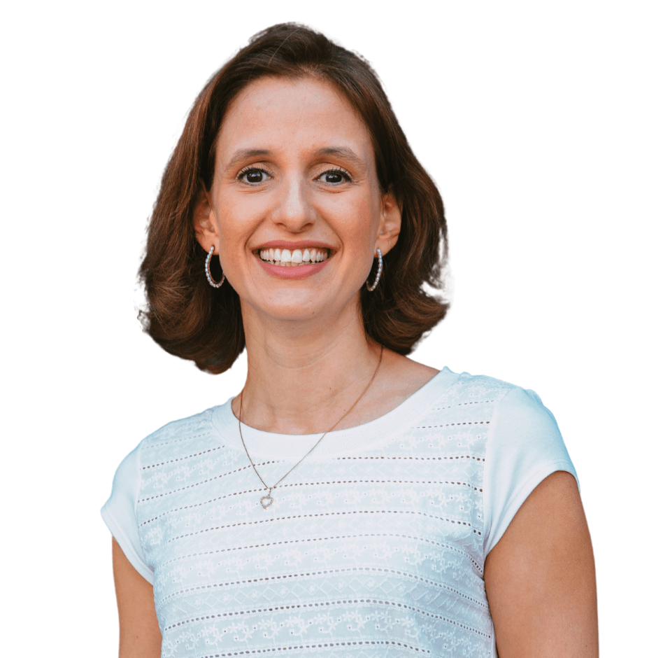A smiling woman with shoulder-length brown hair wearing a light blue top and a necklace.