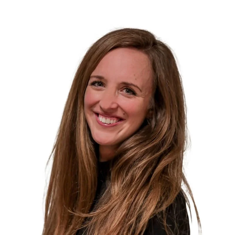 Professional headshot of a smiling woman with long brown hair, wearing a black top against a white background
