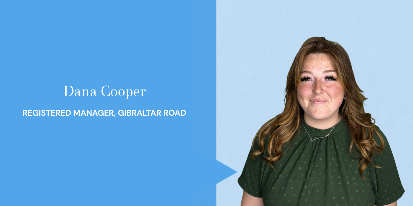Young woman with red hair, freckles, wearing a green polka dot top, smiling, standing against a light blue background, with a blue text box displaying her name and job title.