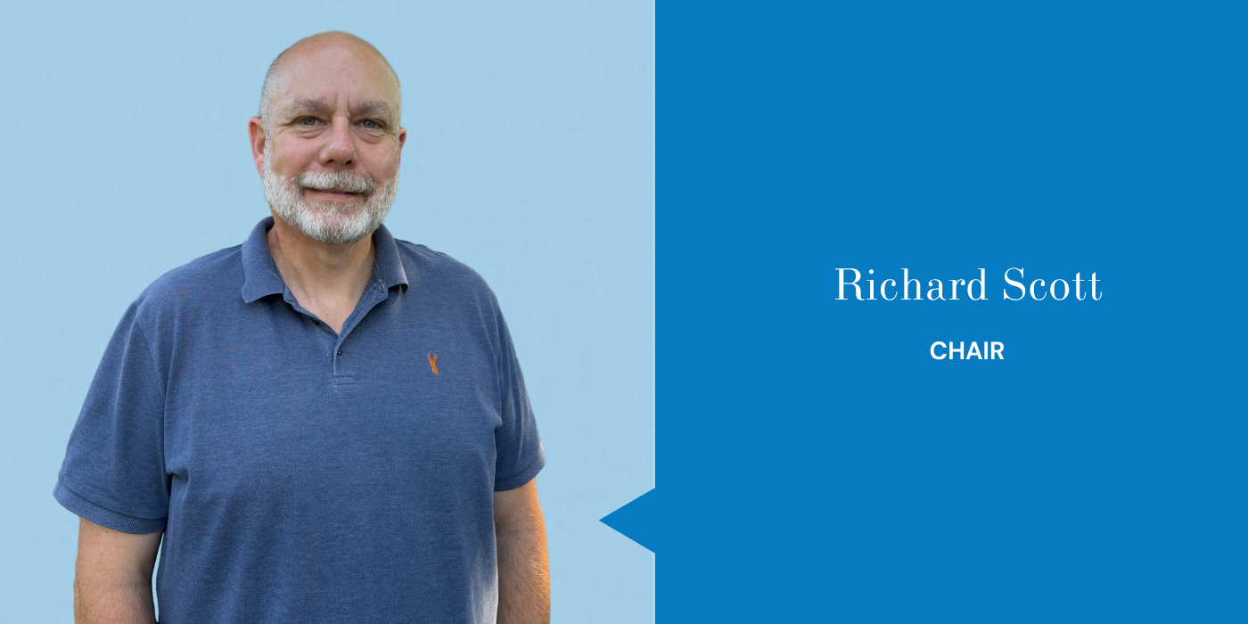 Photograph of Richard Scott, a middle-aged man with a beard and bald head, wearing a blue polo shirt, standing in front of a light blue background, with a blue section on the right displaying his name and title.