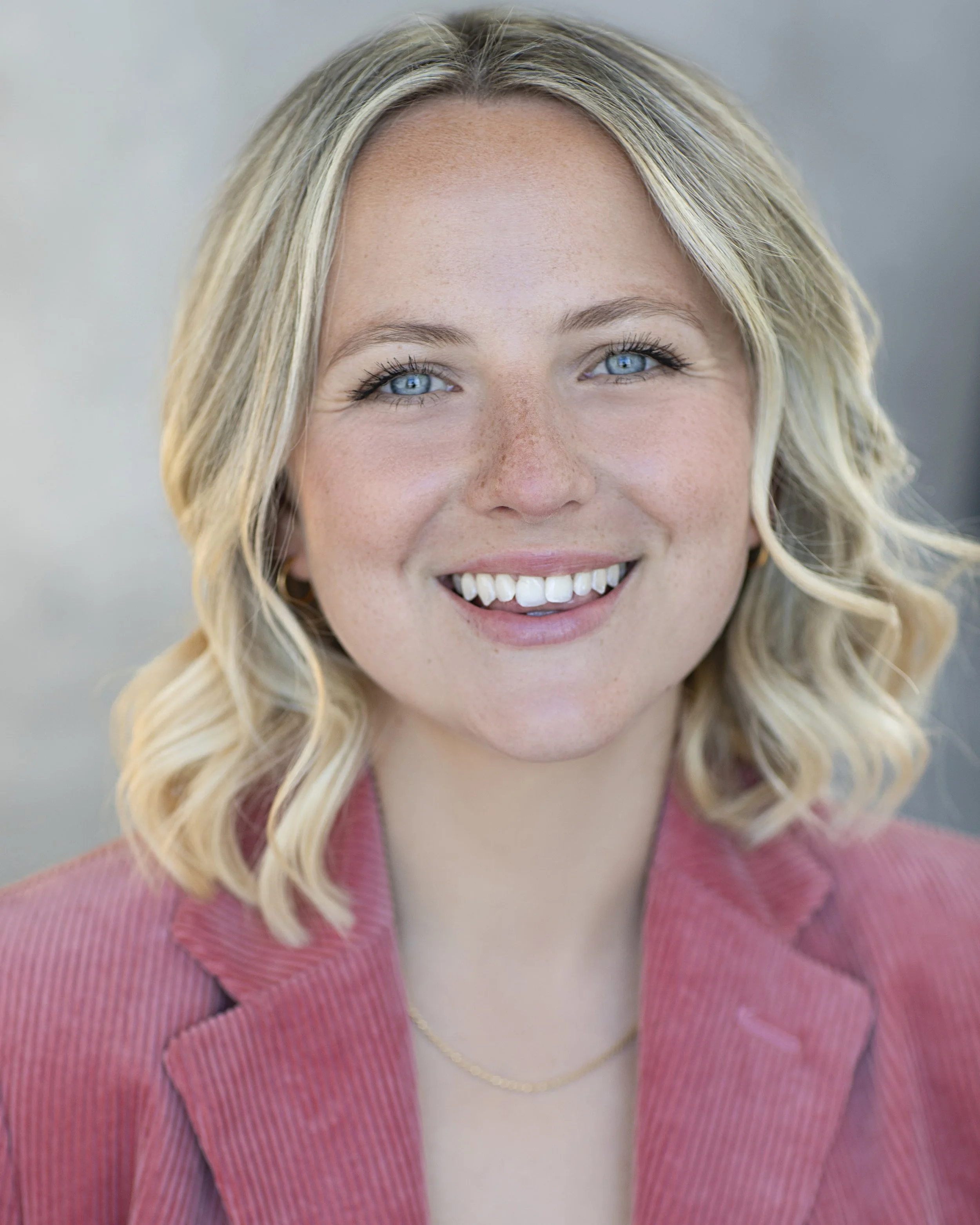 Headshot of Rachel Roland-Whipps wearing a pink jacket