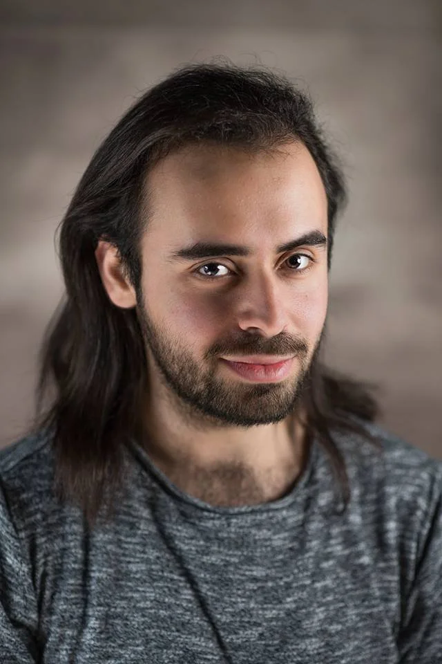 Headshot of Luke Saydon wearing a grey t-shirt