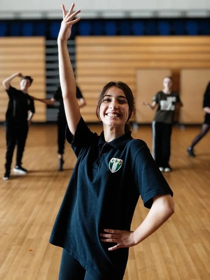 A teenaged girl holds an 'Ozian' pose during an Official Wicked Workshop