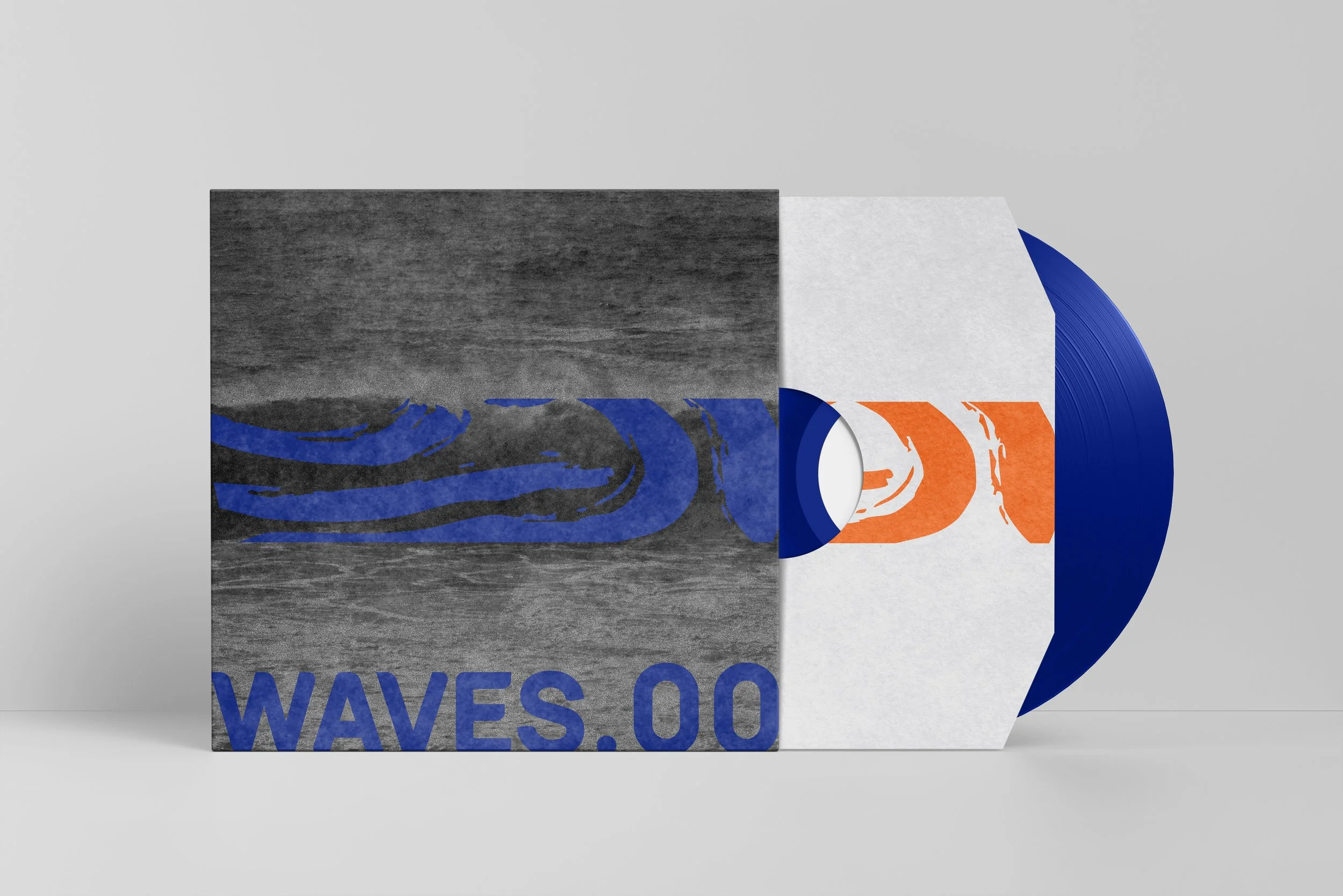 Close-up of a vinyl record partially covered by a paper sleeve with a graphic design and text. The record is blue, and the paper sleeve features a colorful, modern design with orange, white, and blue elements.