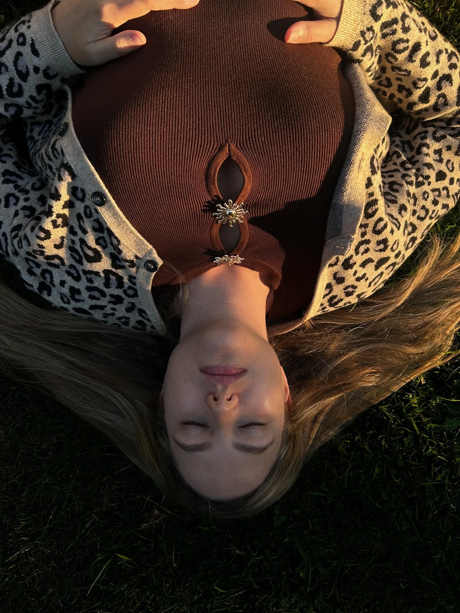 Outdoor yoga relaxation with woman lying on grass, eyes closed in peaceful meditation