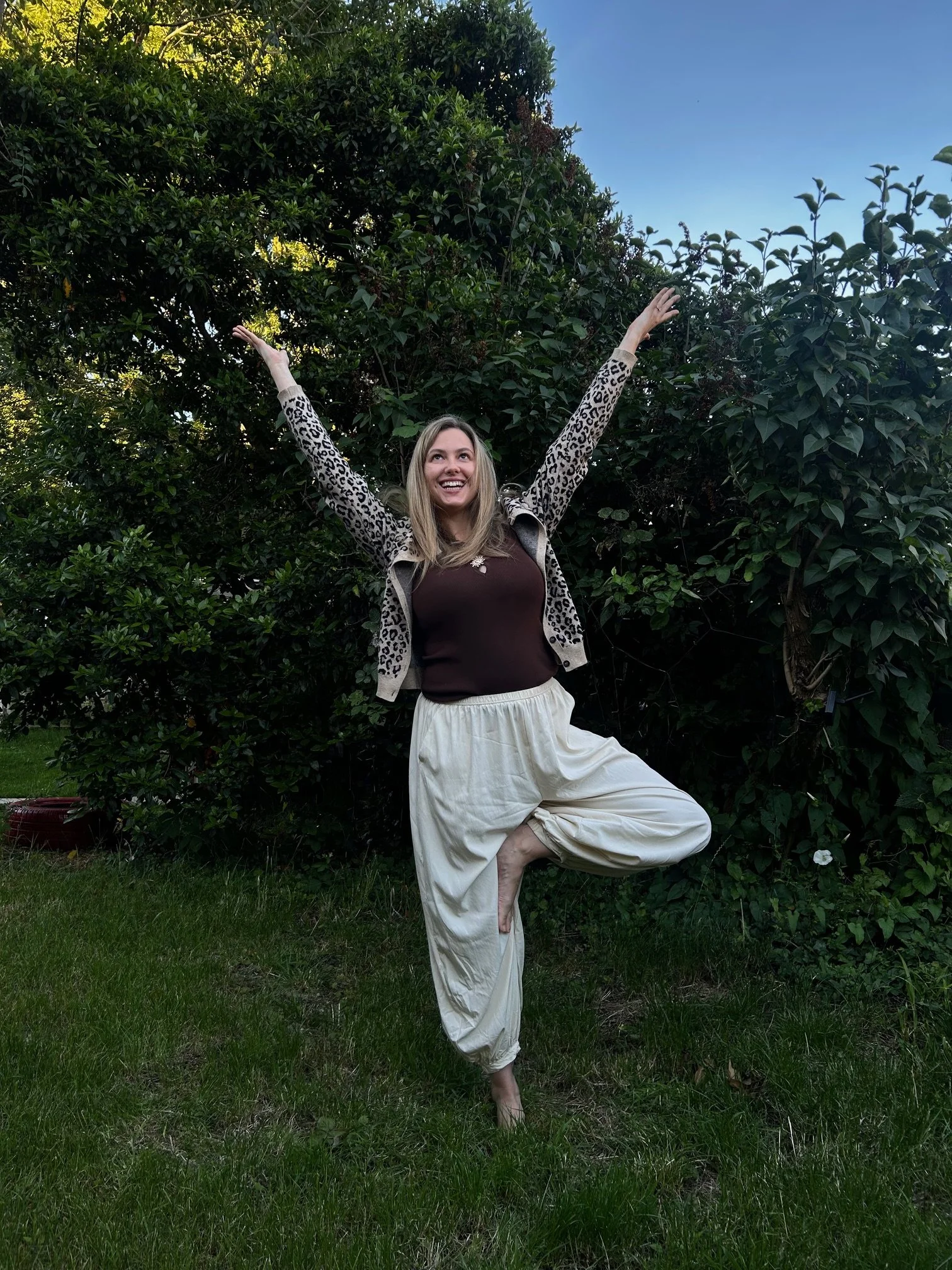 Woman balancing in Tree Pose outdoors, enjoying a mindful yoga practice in nature.