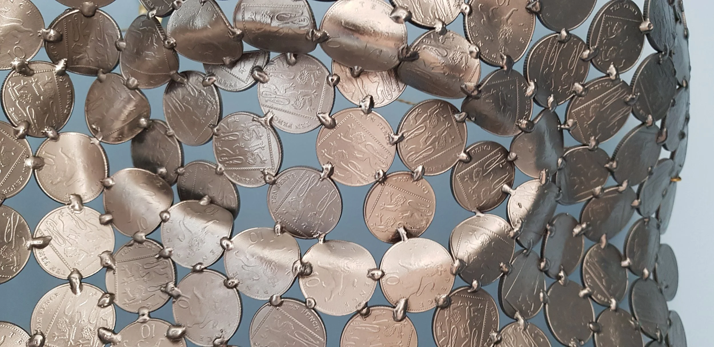A magnificent face sculpture by Shaun Gagg, meticulously crafted from 10p coins. This close-up highlights the intricate detail and precision required to create this remarkable piece