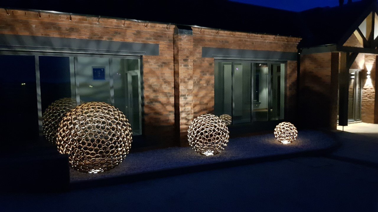 This sculpture is a sphere. Crafted by cutting steel pipes into slices and welding them together from the inside.  Note: The sphere will eventually rust over time.