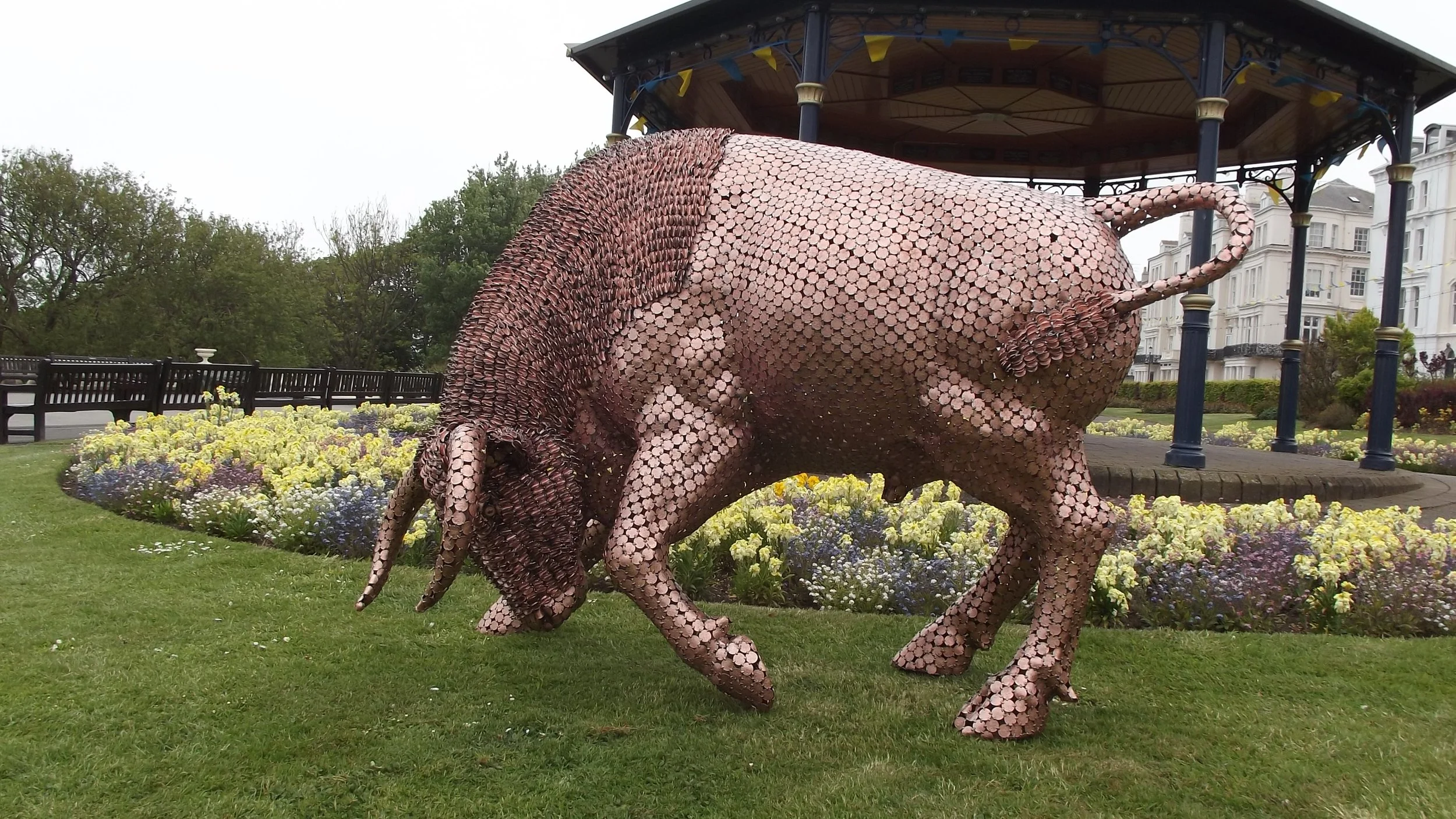 Shaun Gagg's sculpture shows a bull in a charging stance, head lowered and horns forward. Made of tightly arranged two pence coins, it captures strength and motion.