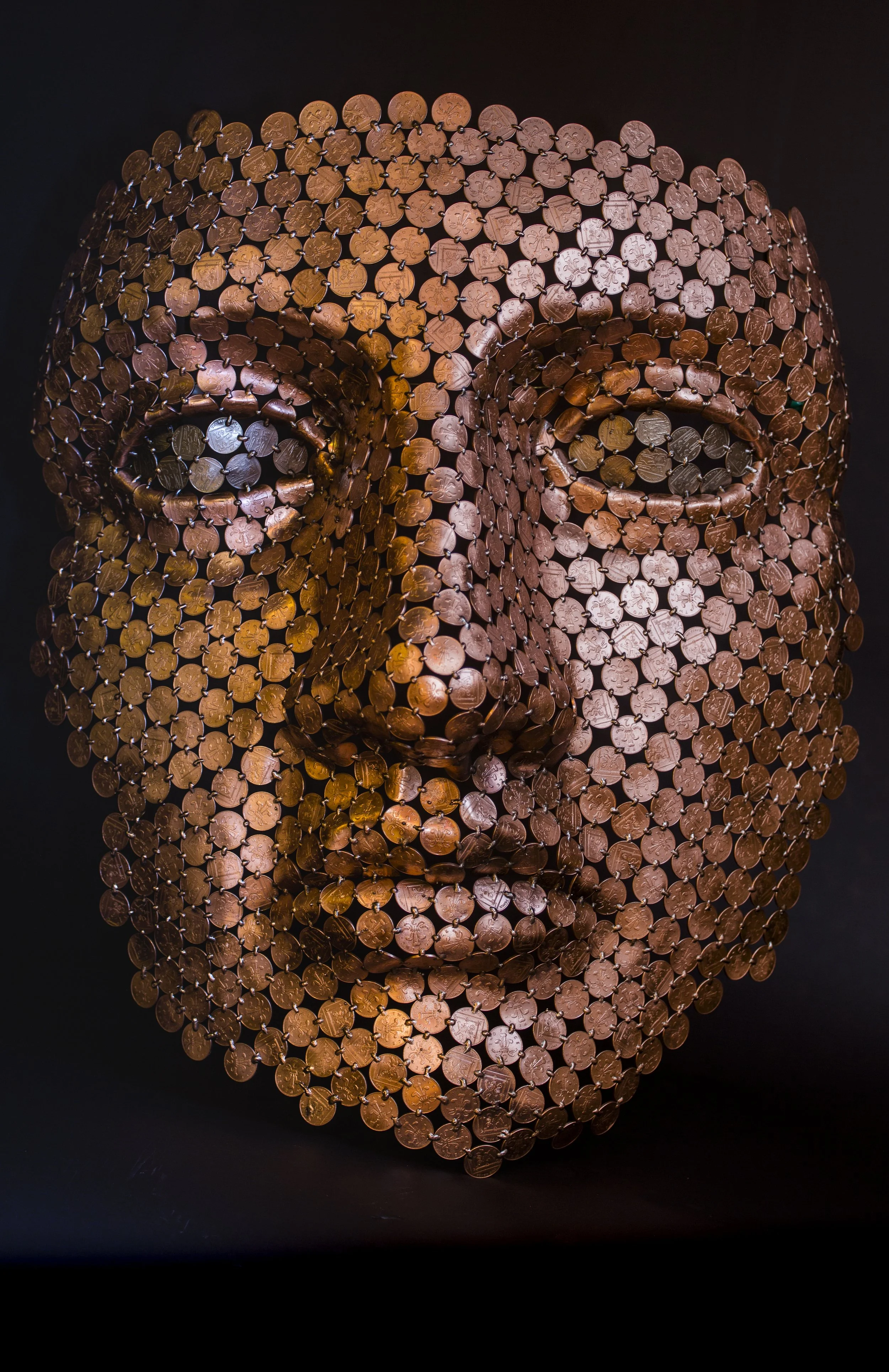 Face sculpture by Shaun Gagg made by welding about 1,000 2p coins, light enough to hang on a wall. The eyes can be customized using 1p, 2p, 5p, or 10p coins.