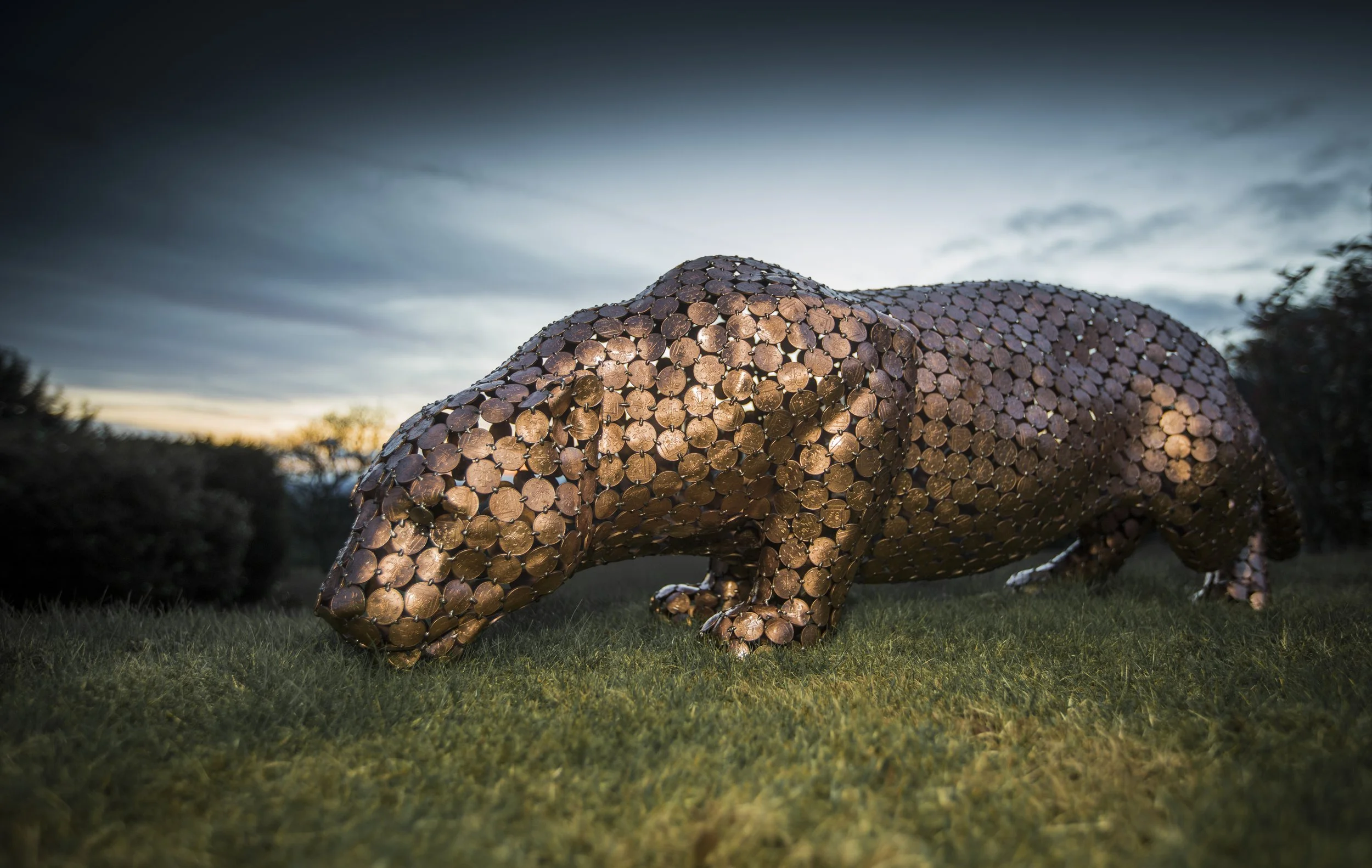 Life-size jaguar sculpture by Shaun Gagg, made from welded 2p coins. The shiny coins reflect light, highlighting the jaguar's powerful form and texture