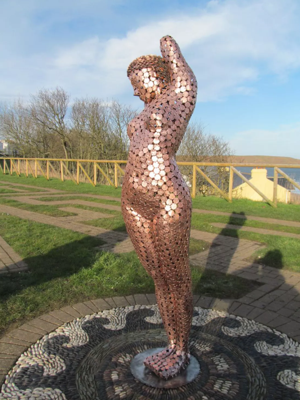 life-size sculptures of a woman by Shaun Gagg, crafted entirely from 2p coins. This striking piece intricately explores themes of value and femininity through its unique coin construction.