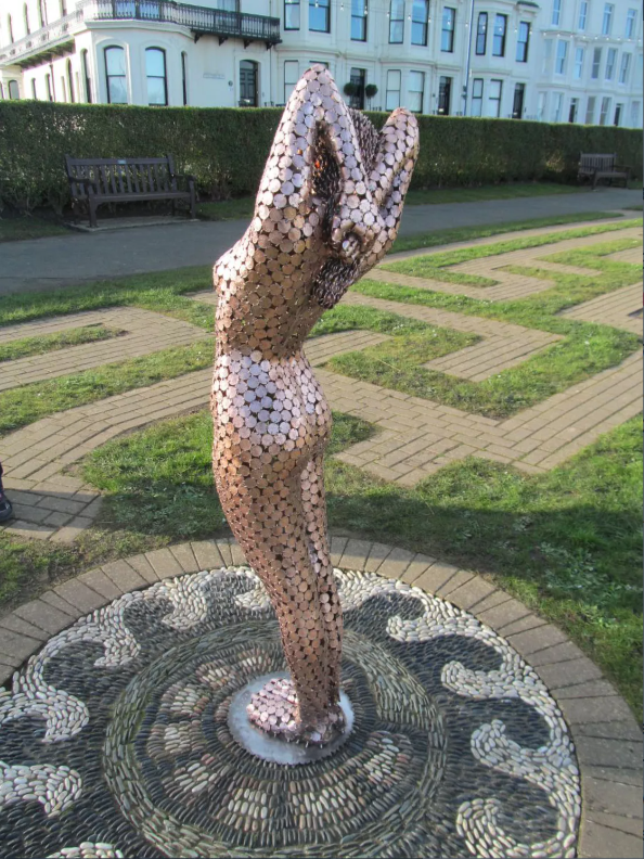 life-size sculptures of a woman by Shaun Gagg, crafted entirely from 2p coins. This striking piece intricately explores themes of value and femininity through its unique coin construction.