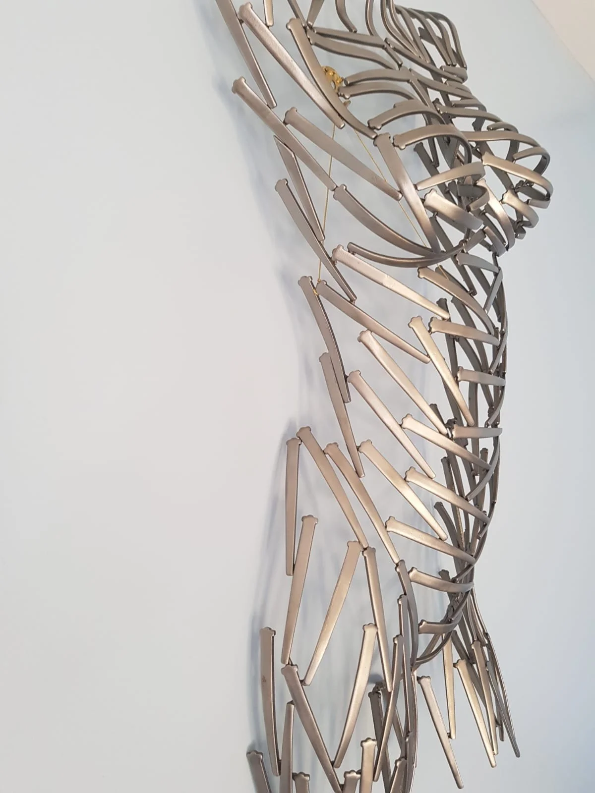 A torso sculpted from nails—sharp, textured, and raw. Suspended or grounded, it plays with light and shadow, turning metal into movement.