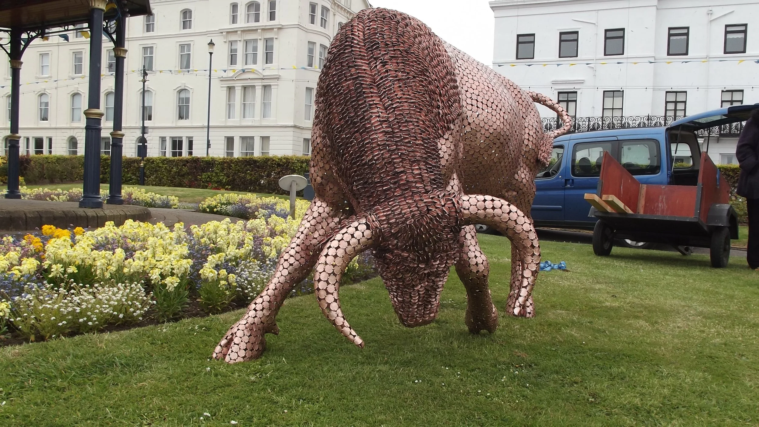 Shaun Gagg's sculpture shows a bull in a charging stance, head lowered and horns forward. Made of tightly arranged two pence coins, it captures strength and motion.